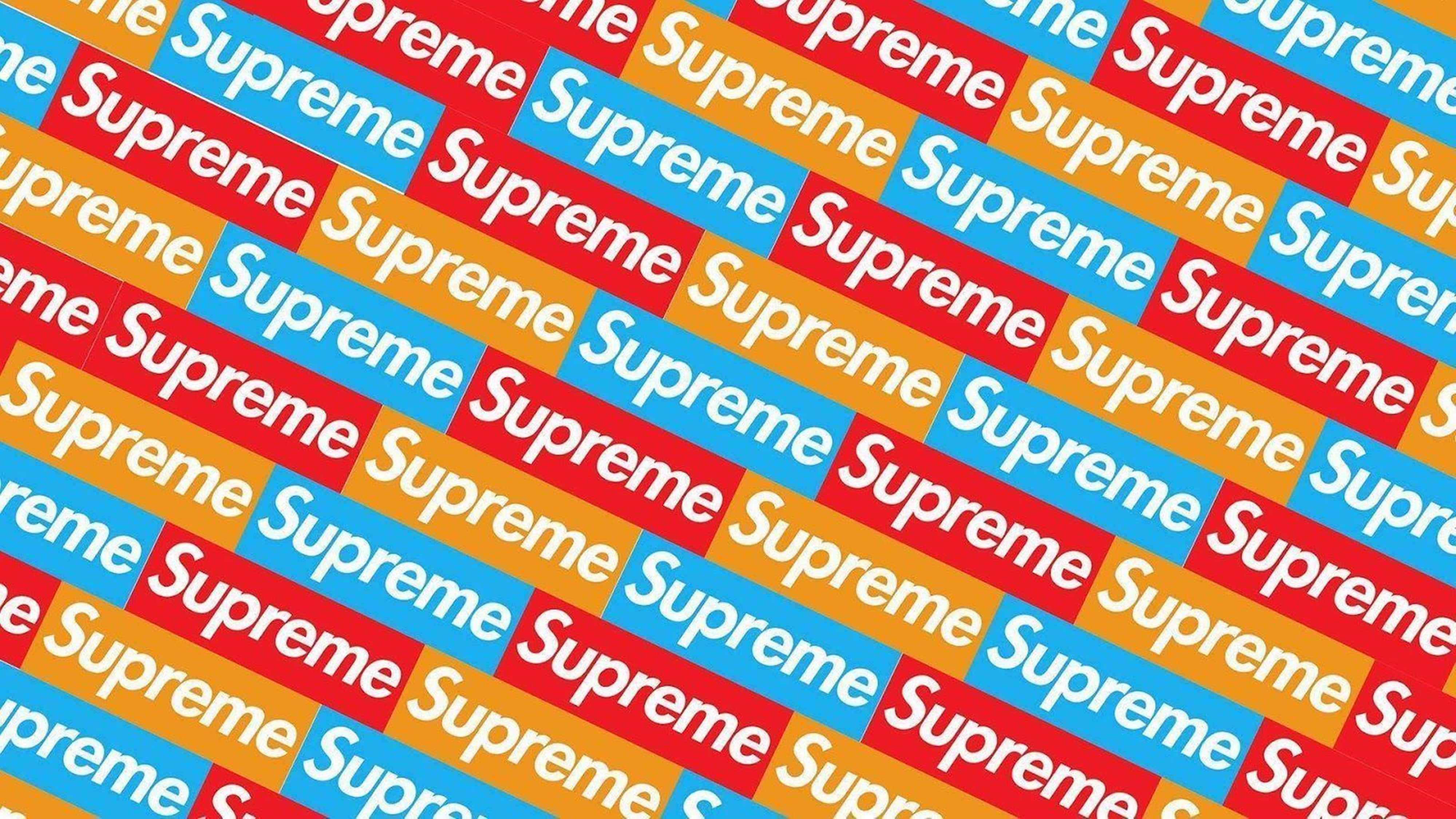 4K Supreme 紅黃藍圖案壁紙 壁紙 — 一個充滿活力的重複圖案，由紅色、藍色和橙色方塊中的Supreme標誌斜向排列在框架上。