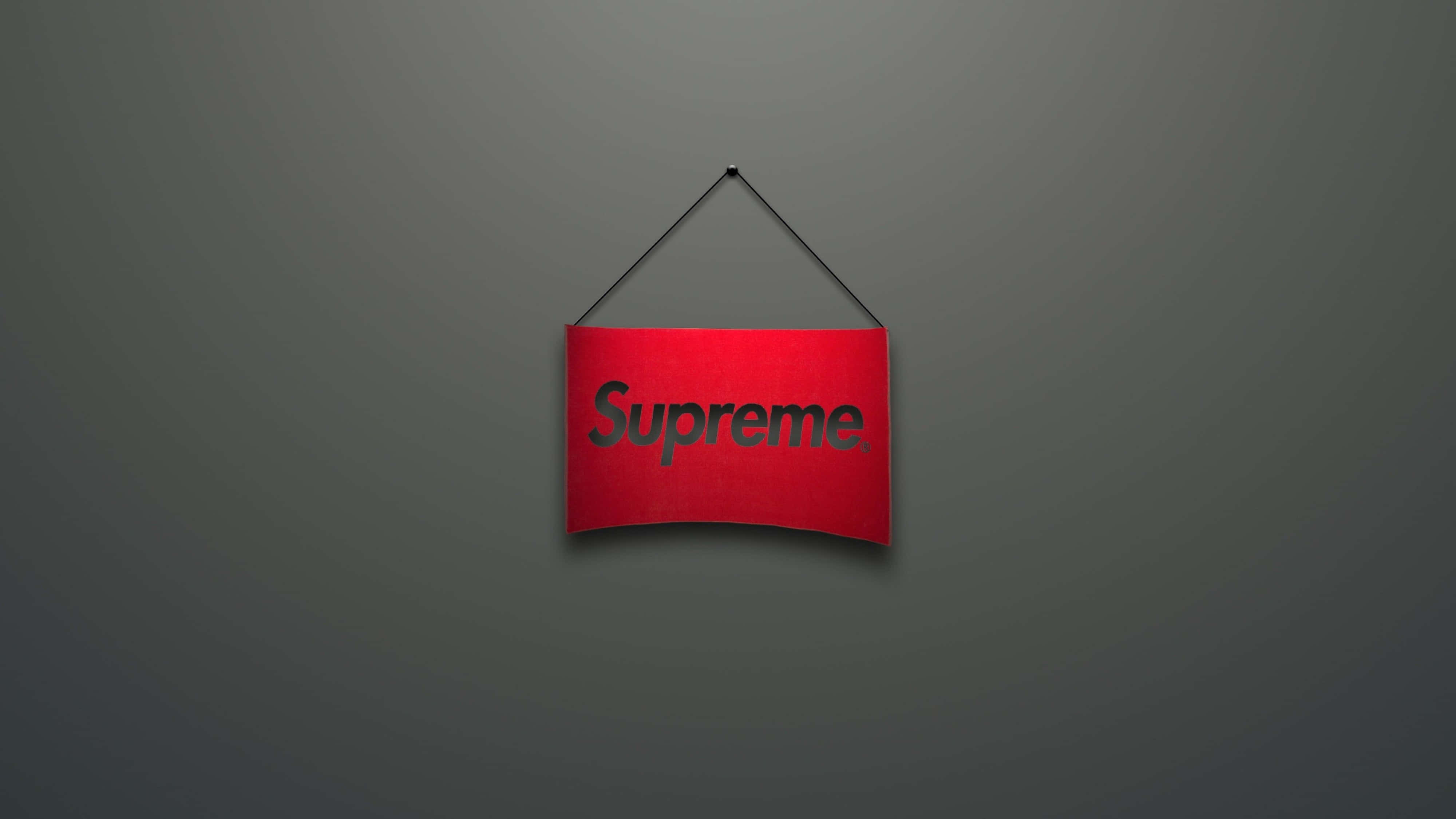 4K Supreme 懸掛紅牌 壁紙 — 一個紅色Supreme標誌牌掛在柔和灰色漸變牆的中心，光線柔和。