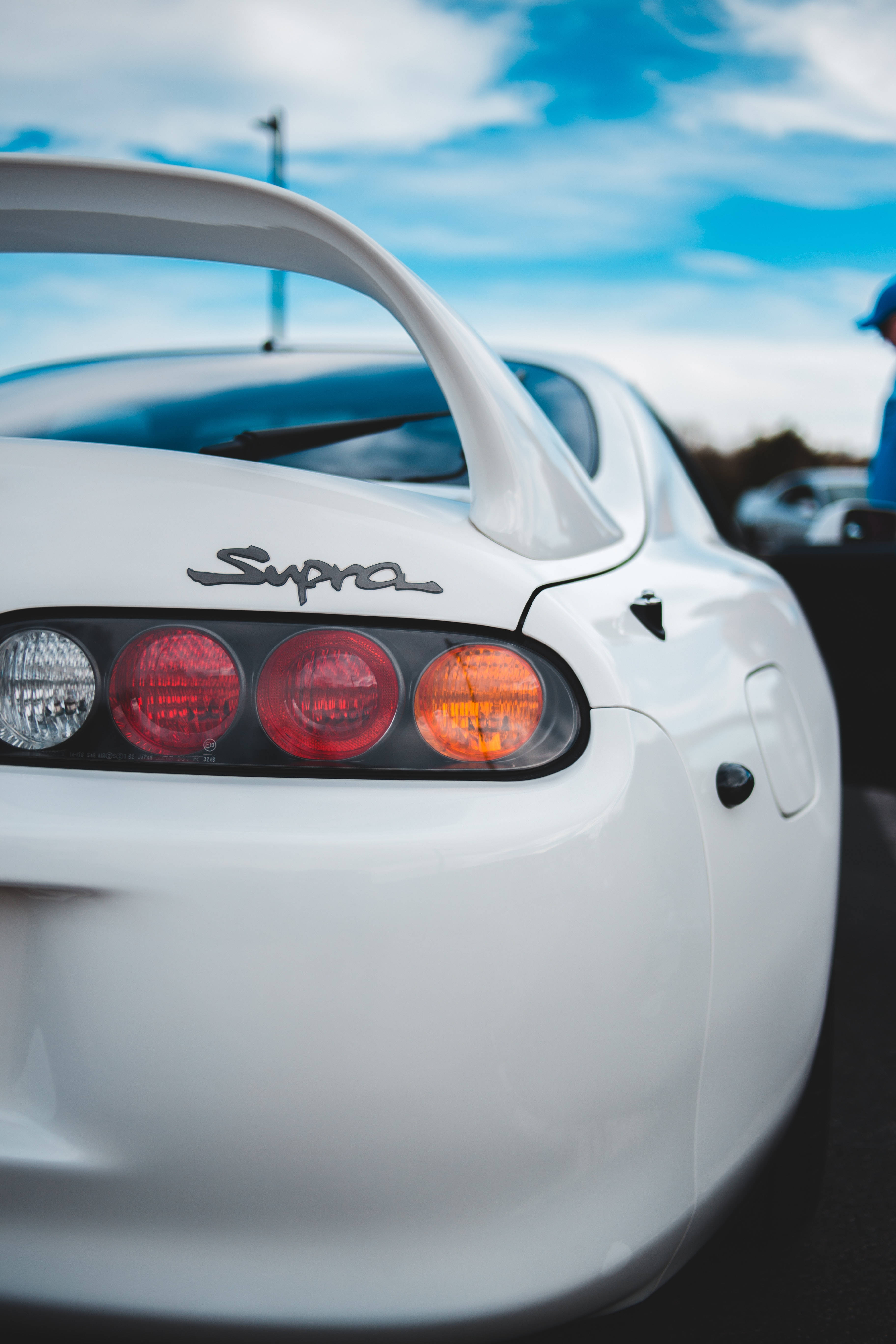 4K Toyota Supra後視特寫 壁紙 — 白色豐田Supra車尾特寫，紅色尾燈在明亮藍天下發光。