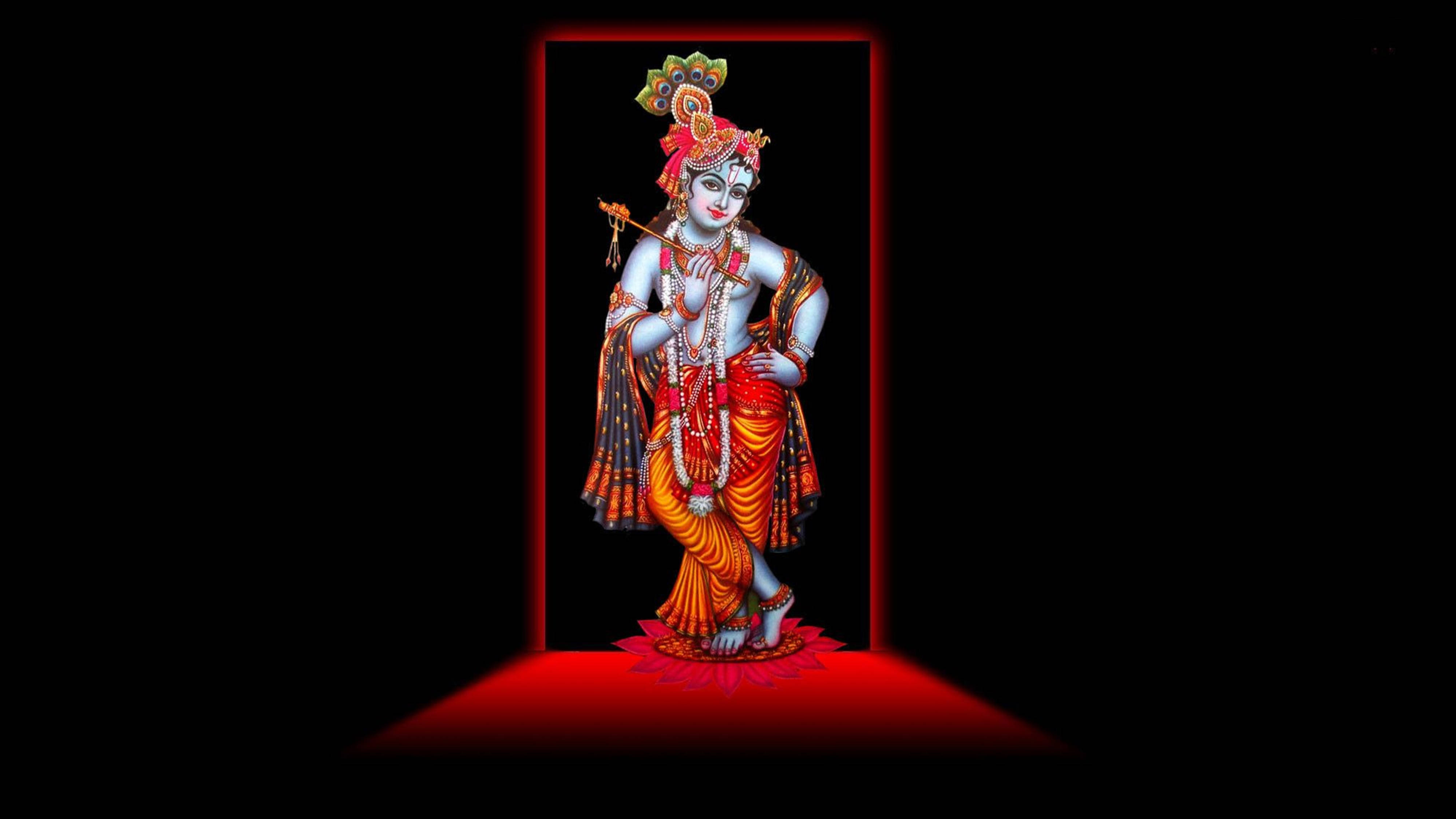 克里希那 4K 穿著 Vaijayanti Mala 壁紙 — 一位神聖的藍皮膚神祇，頭戴孔雀冠，手持長笛，站在紅色照亮的門口，背景為黑色。