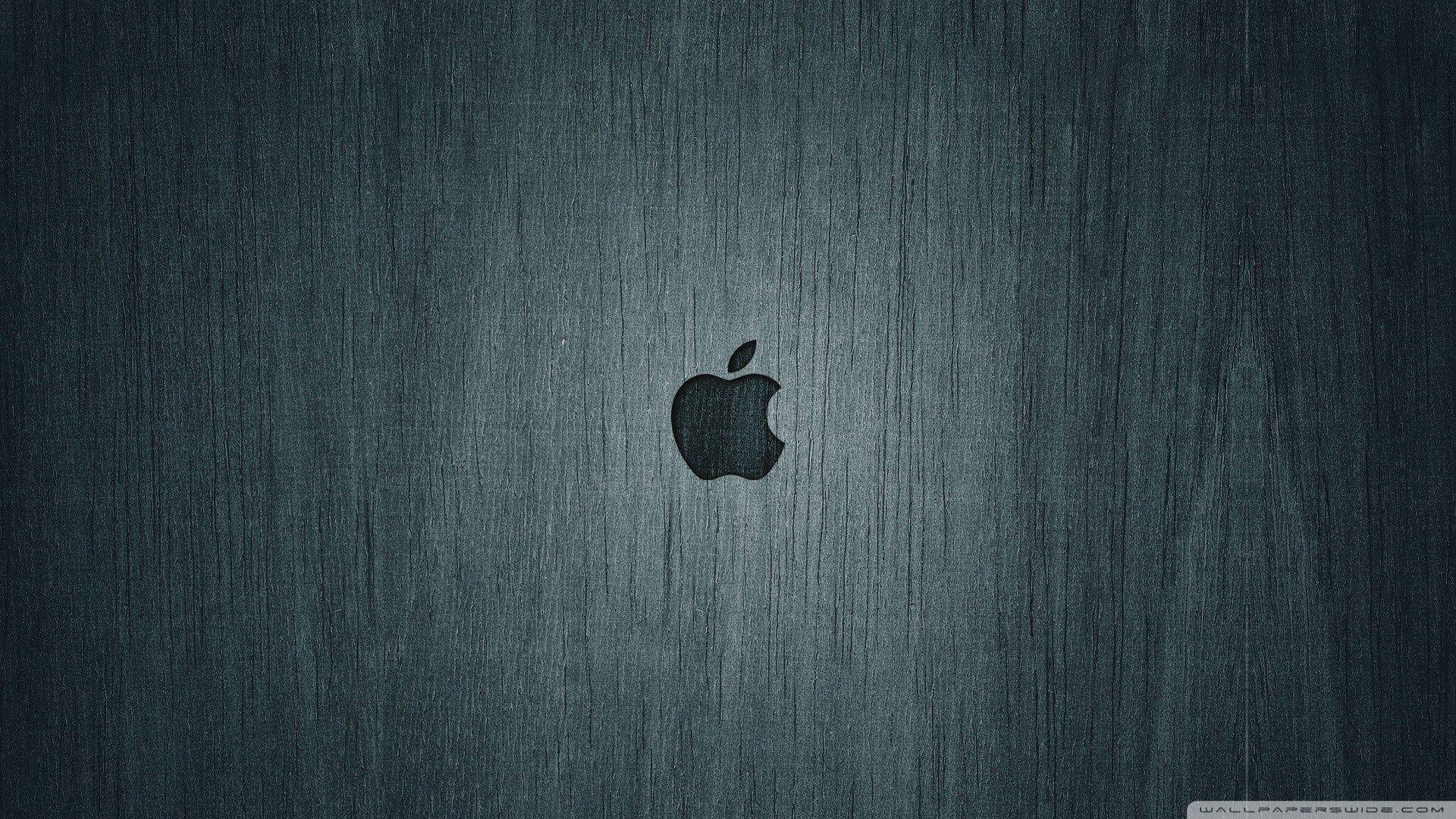 灰色背景上的蘋果標誌 4K 壁紙 — 一個時尚的Apple標誌置中於帶有細微垂直紋理的拉絲深色金屬表面上。