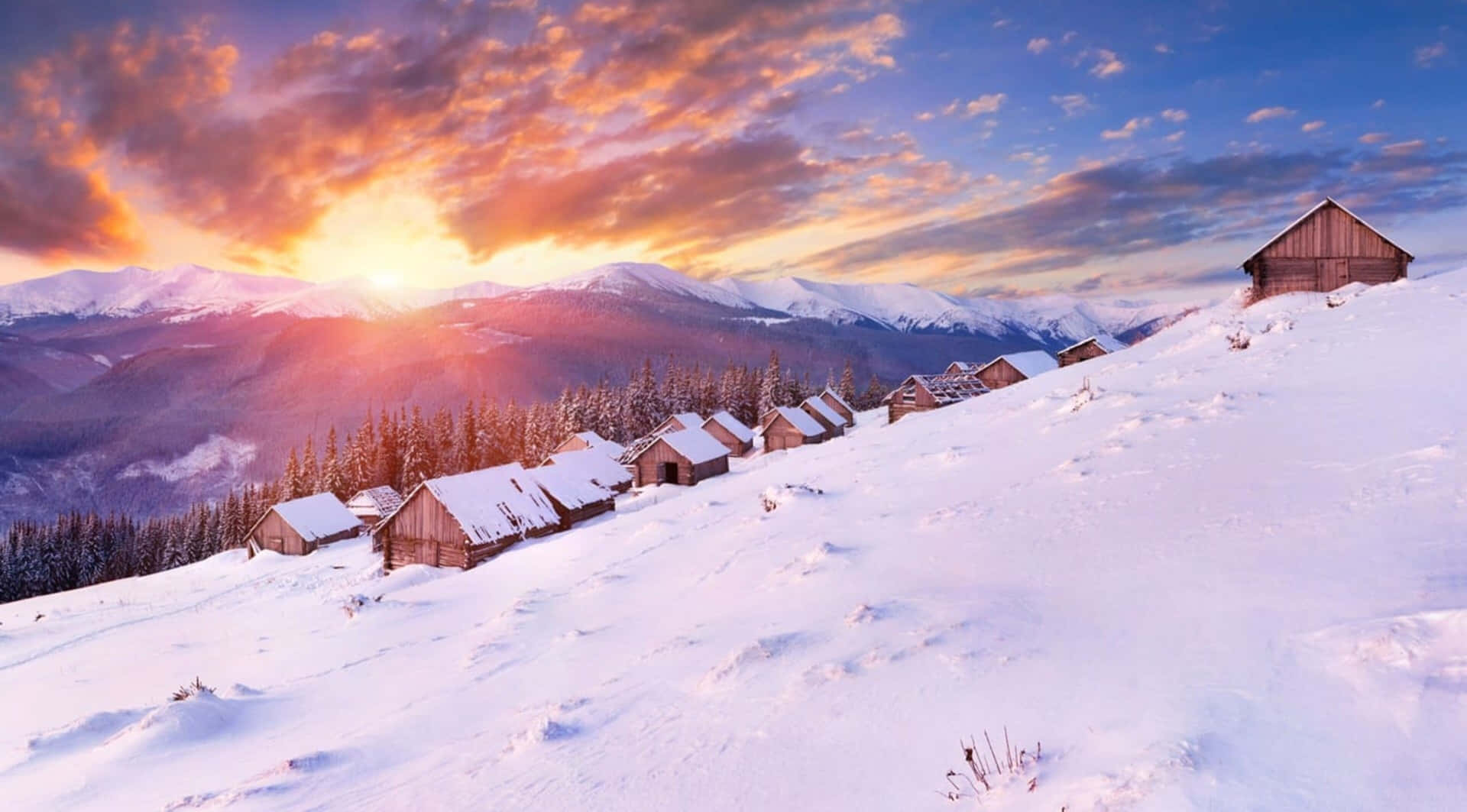 夕陽下白雪覆蓋的山村，有木屋。