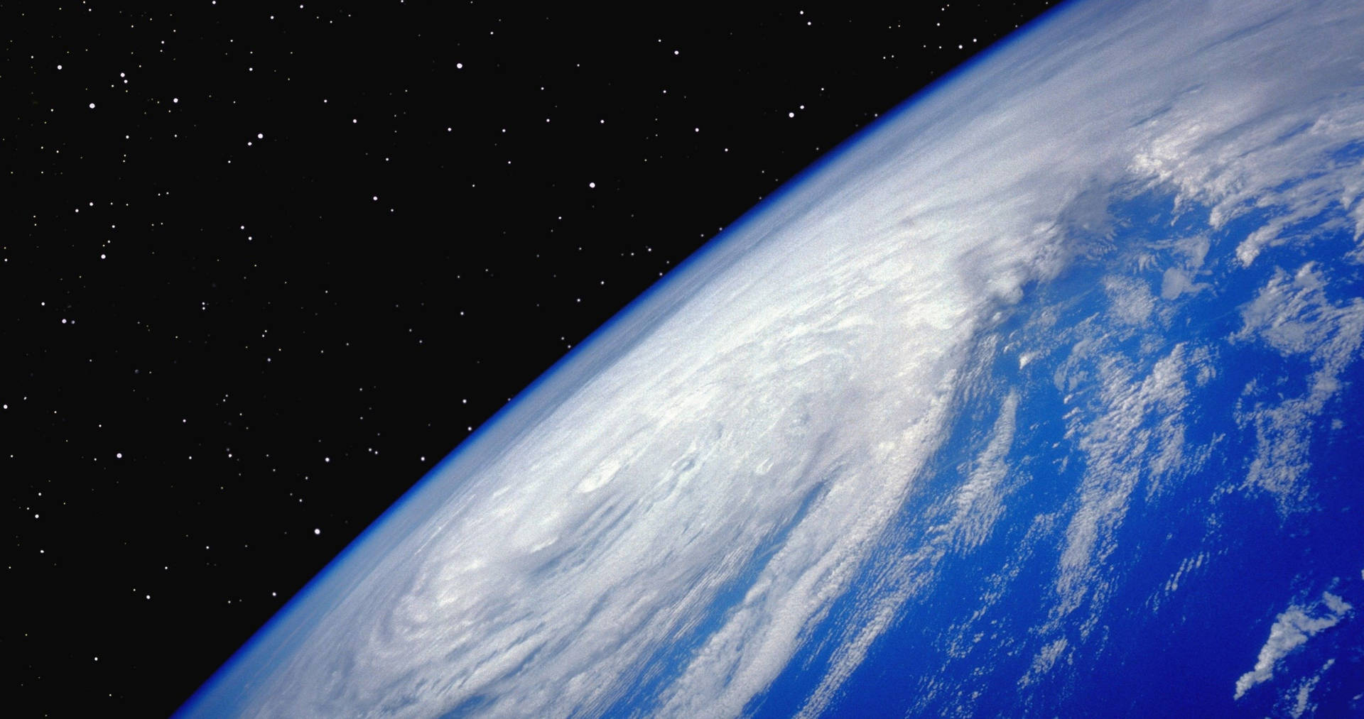 從太空看到的地球，背景有旋轉的雲層和星星。