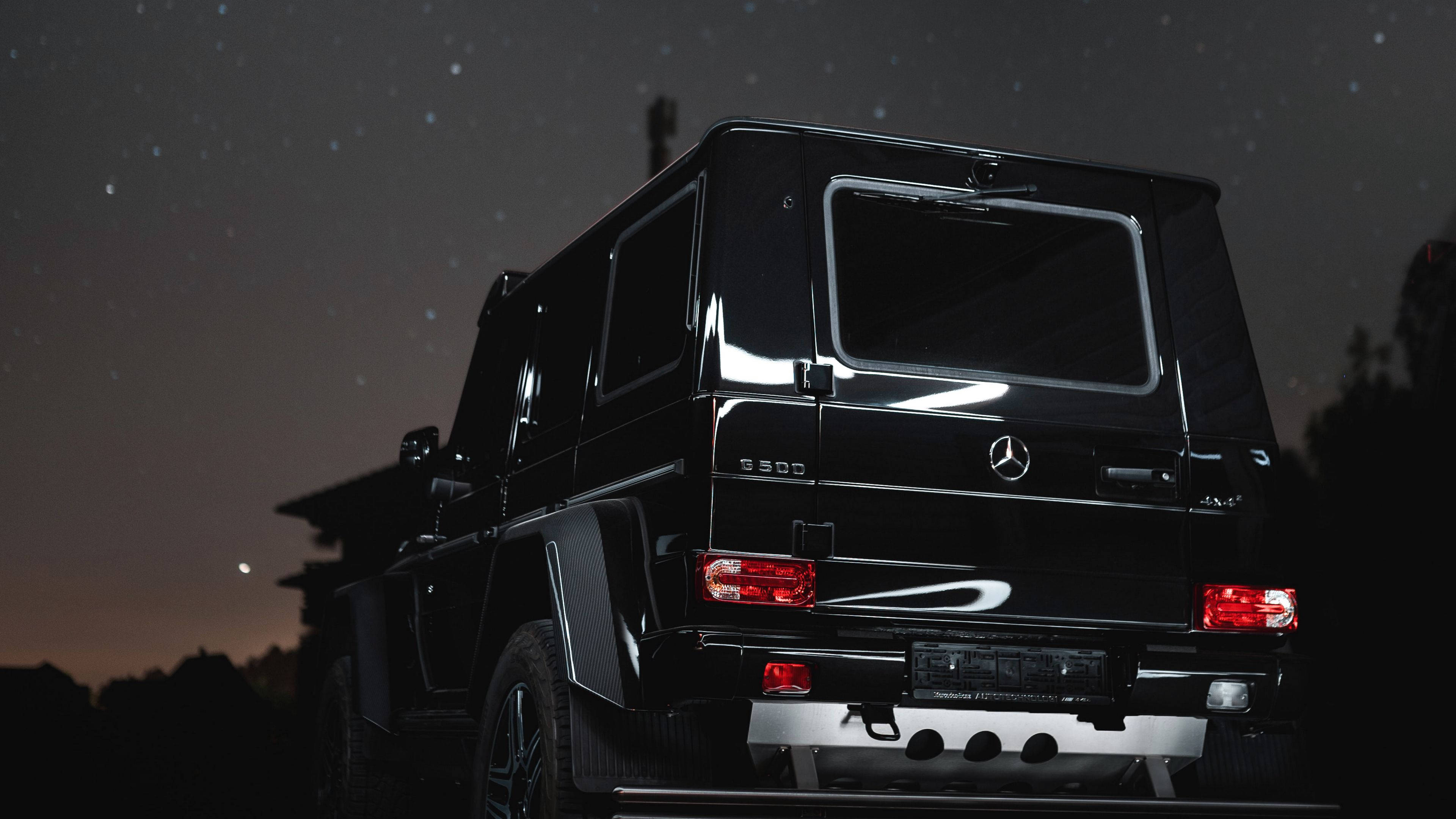 4K 奔馳 G 級黑色 壁紙 — 一輛黑色Mercedes G-Class SUV停在星空下，紅色尾燈閃爍，遠處有月亮。