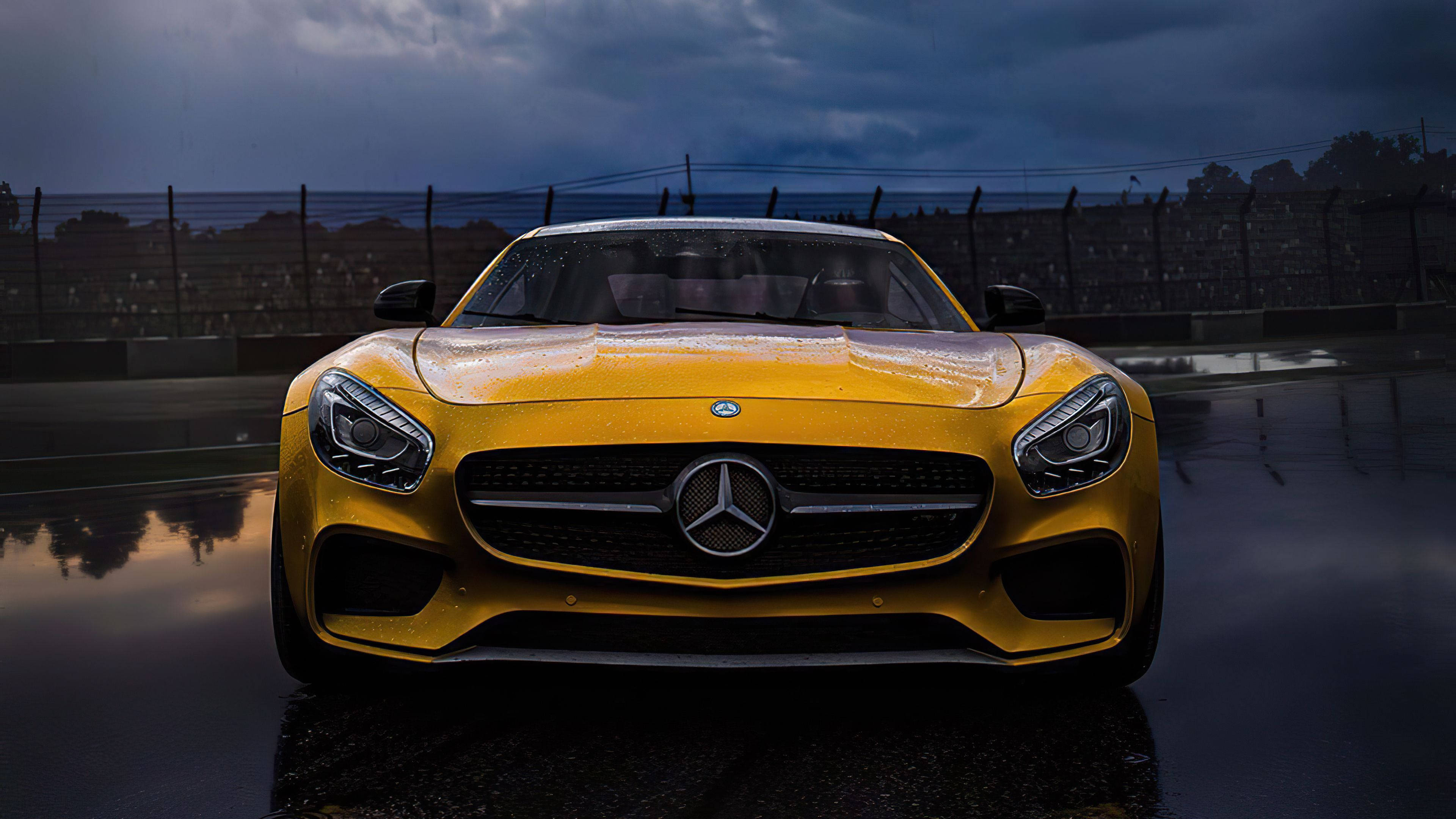 4K 奔馳炫麗黃色款 壁紙 — 一輛充滿活力的黃色Mercedes-AMG GT跑車在暴風雨的天空下，在潮濕的賽道上閃閃發光。