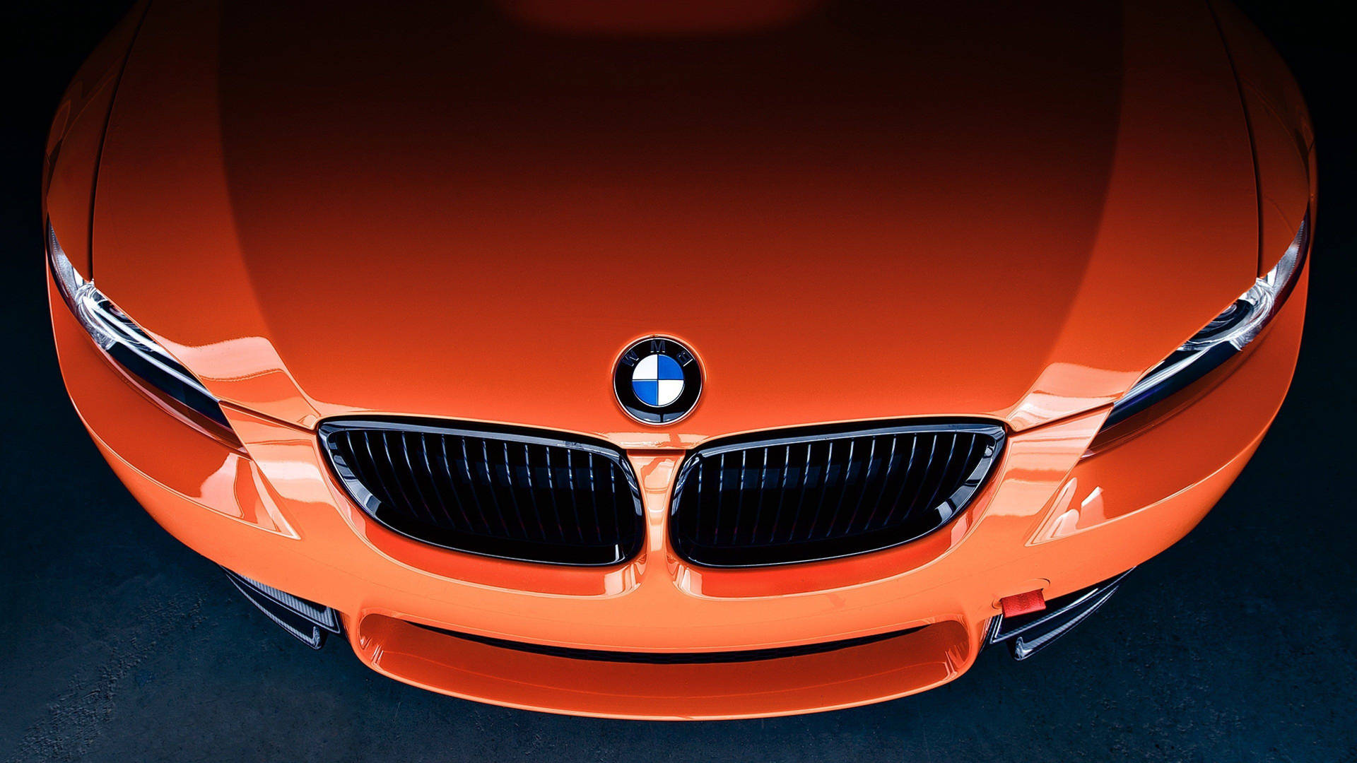 特寫橙色寶馬汽車的前格柵和頭燈，在工作室燈光下。 — 4K BMW 壁紙 壁紙