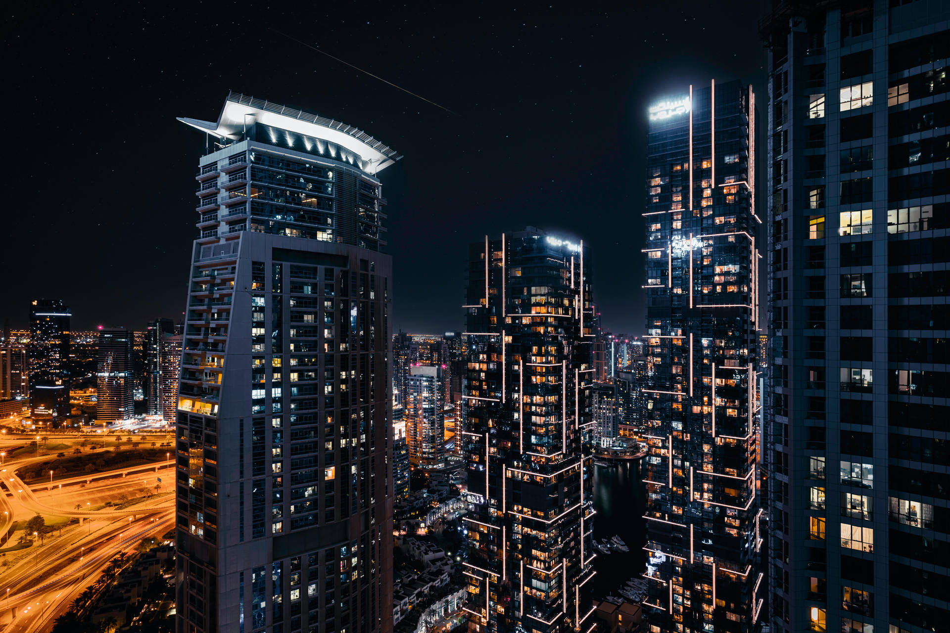 星空下，燈火通明的摩天大樓和發光的道路構成的城市天際線