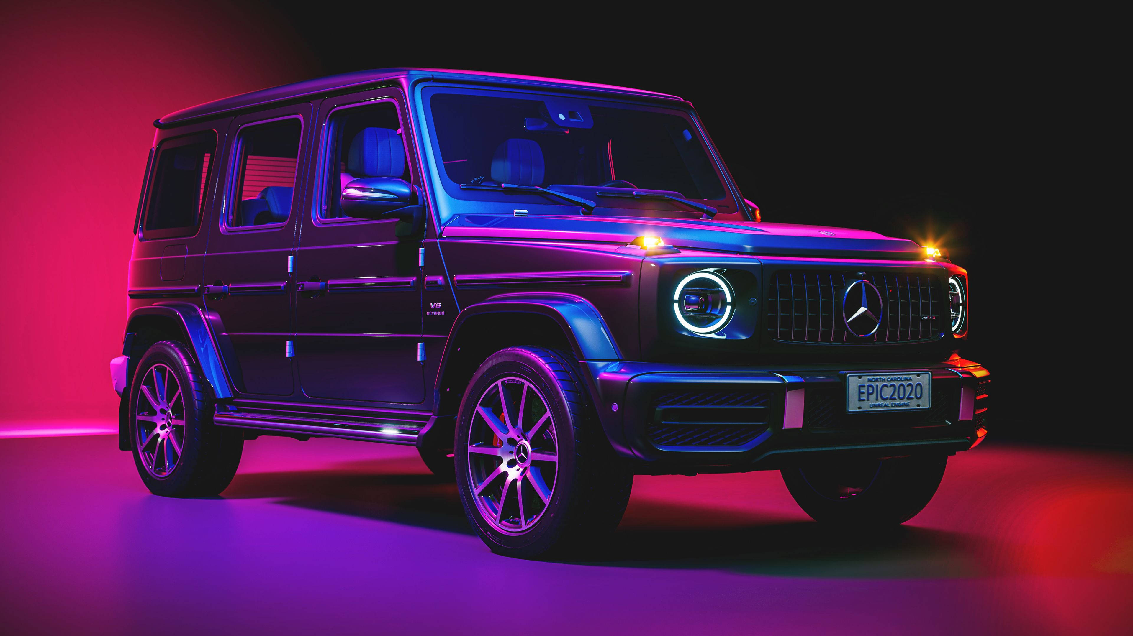4K 梅賽德斯 G 級 2021 壁紙 — 一輛梅賽德斯 G-Class SUV 在黑暗的攝影棚背景下，在充滿活力的粉紅色和藍色霓虹燈下發光。