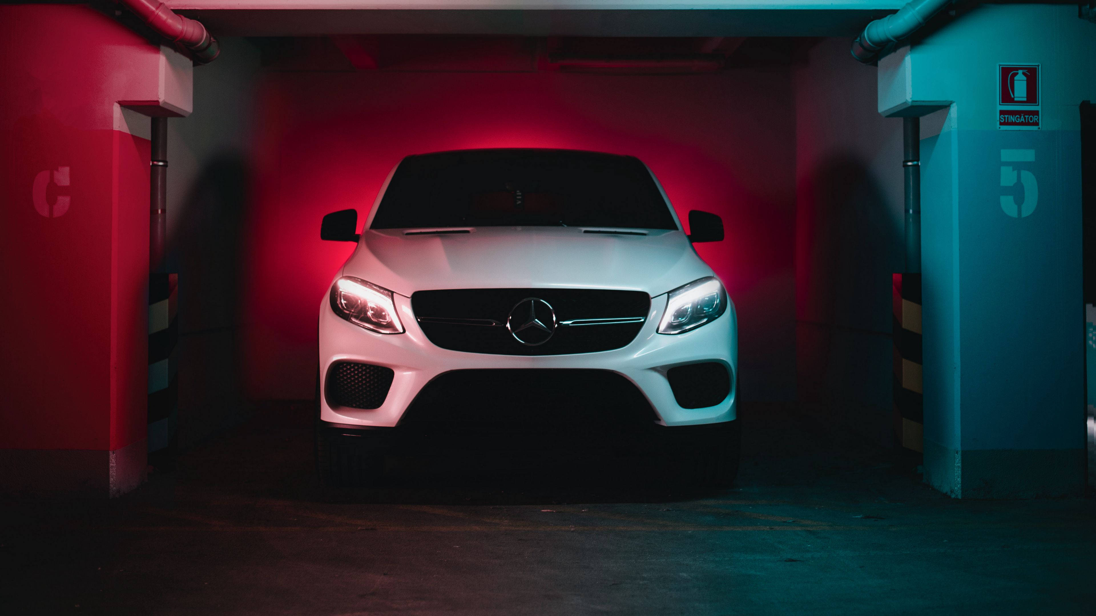 4K 梅賽德斯白色 GLC Coupe 壁紙 — 一輛白色Mercedes SUV在昏暗的地下停車場中，在戲劇性的紅藍霓虹燈下閃耀。