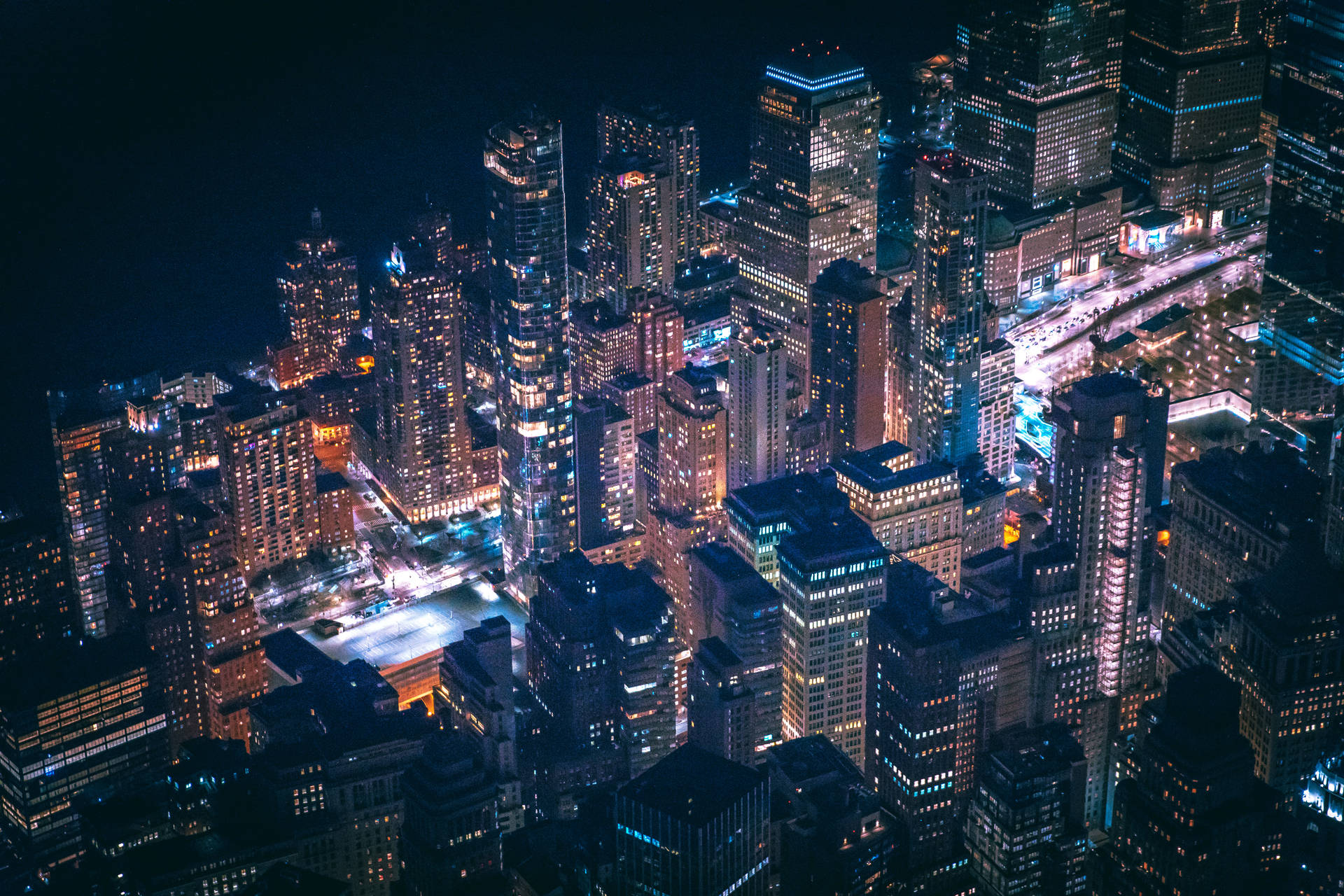 夜間鳥瞰密集的城市天際線，摩天大樓燈火通明。