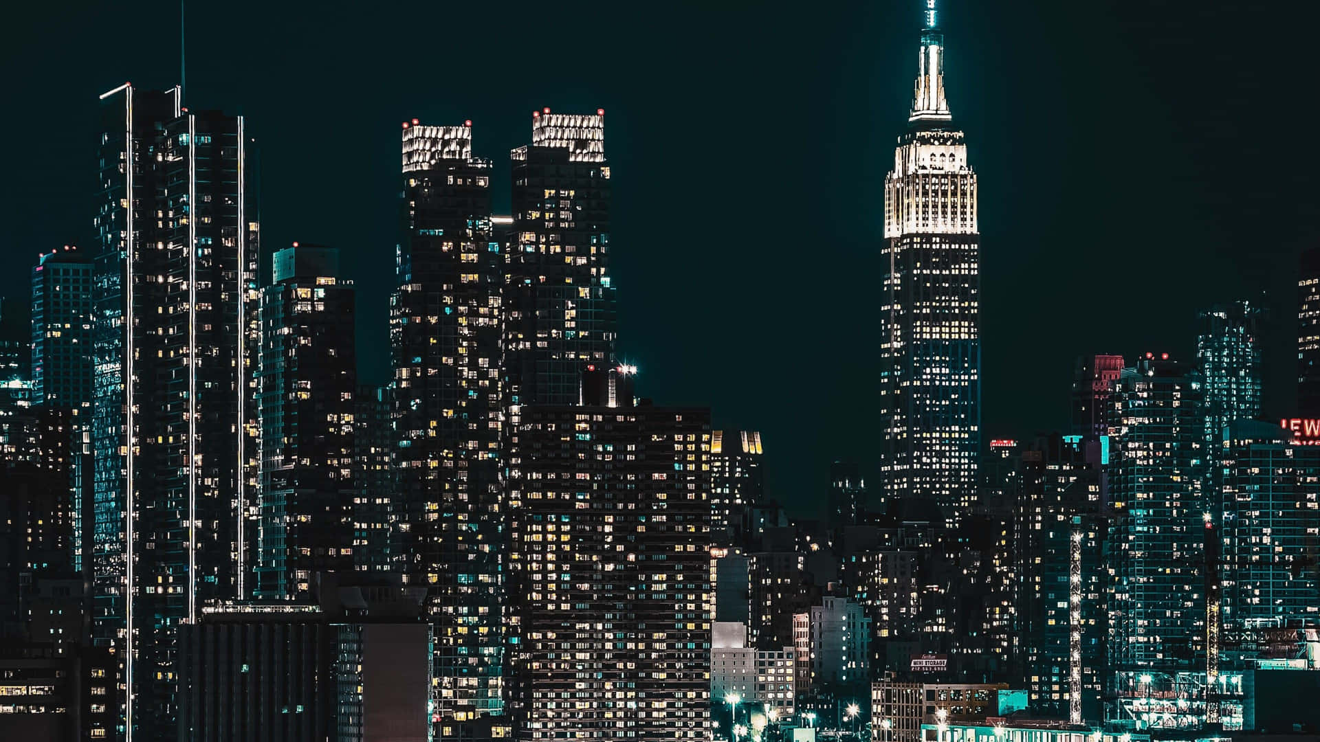 紐約市天際線的夜景，燈火通明的摩天大樓和帝國大廈。