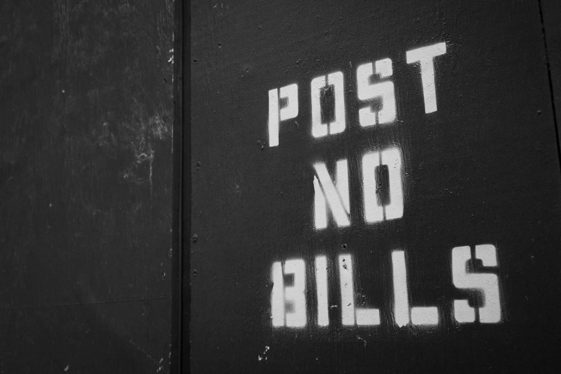 黑色金屬門上的白色模板文字寫著「POST NO BILLS」