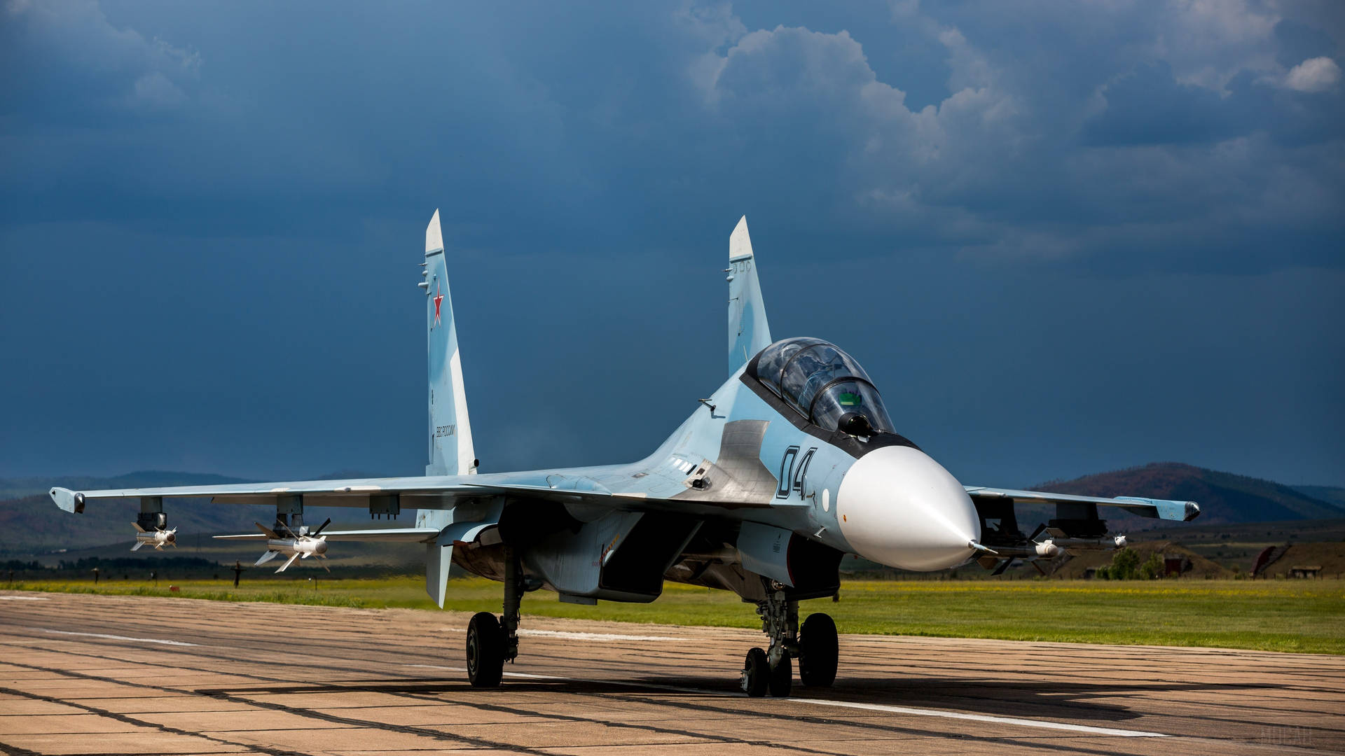 一架軍用戰鬥機在暴風雨天空下的跑道上。
