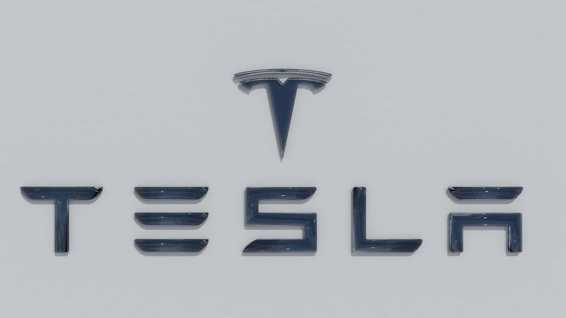 灰色表面上帶有金屬字體的Tesla標誌。