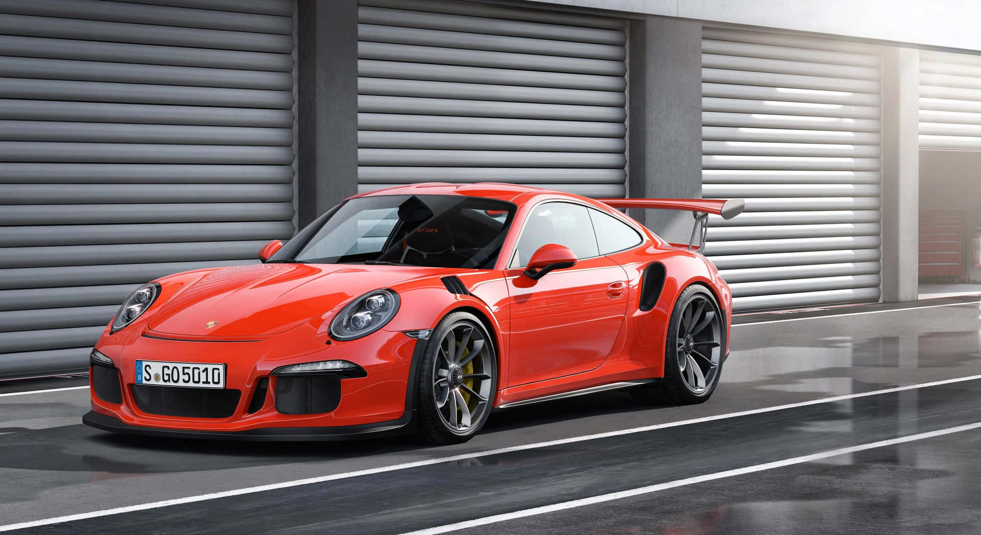 紅色保時捷911 GT2 RS停在潮濕路面的車庫門前。