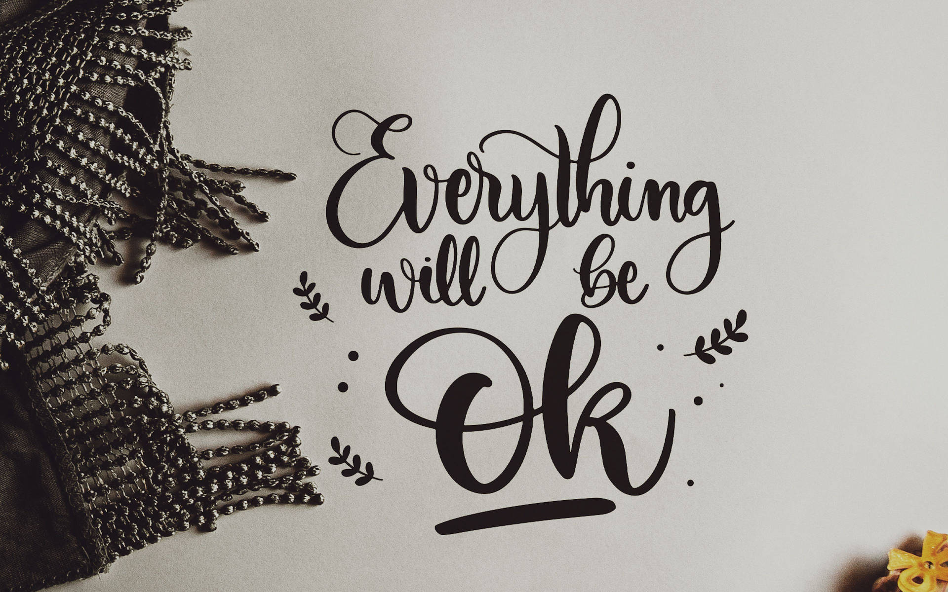 勵志名言 Everything will be Ok 以優雅的黑色字體呈現，配有裝飾葉子和珠飾圍巾。