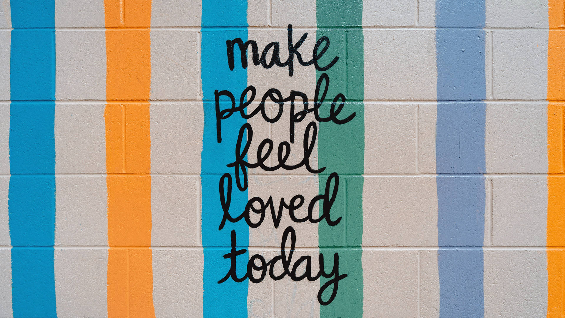 彩色條紋牆壁，帶有手寫勵志訊息 make people feel loved today。