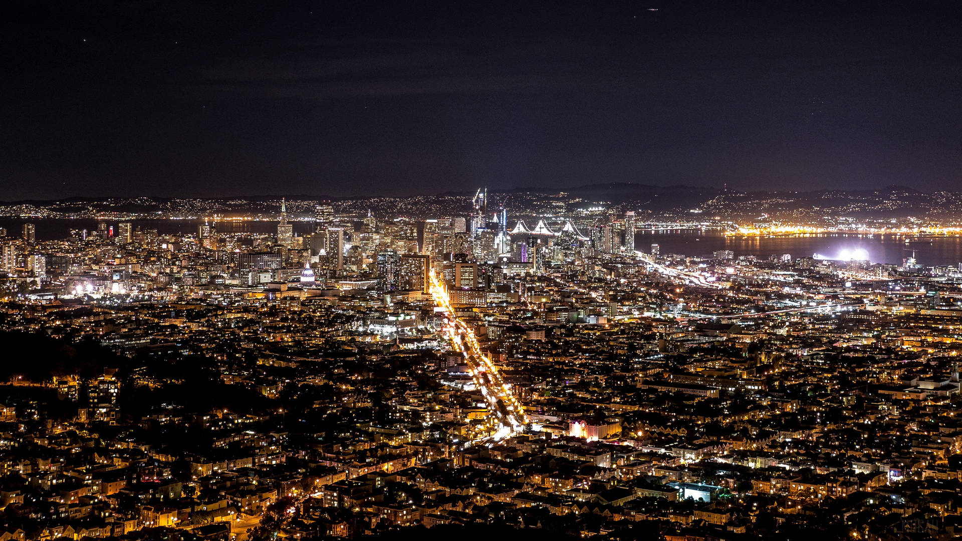 夜晚鳥瞰密集照明的城市，街道和摩天大樓發光。