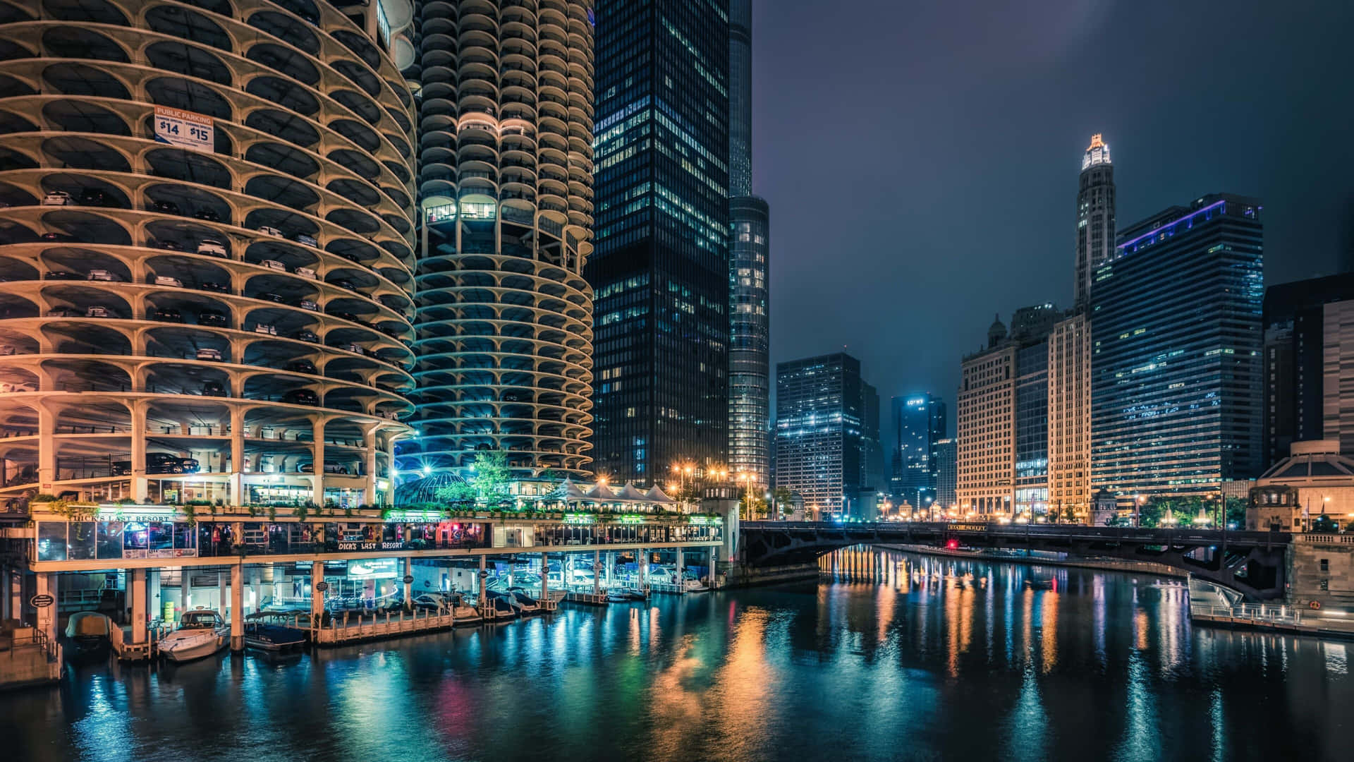 夜間城市天際線，發光的建築物倒映在河流中。