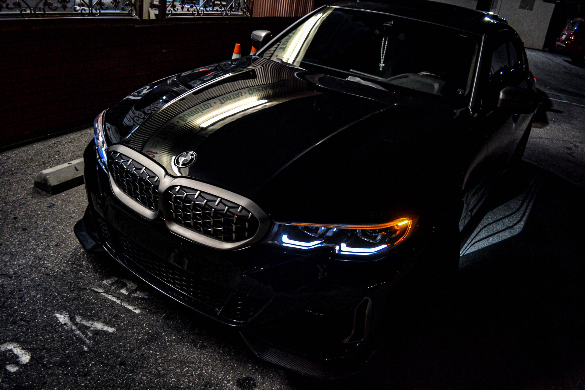 黑色BMW跑車停放在黑暗的城市車庫中，車頭燈閃爍。 — 4K BMW 壁紙 壁紙