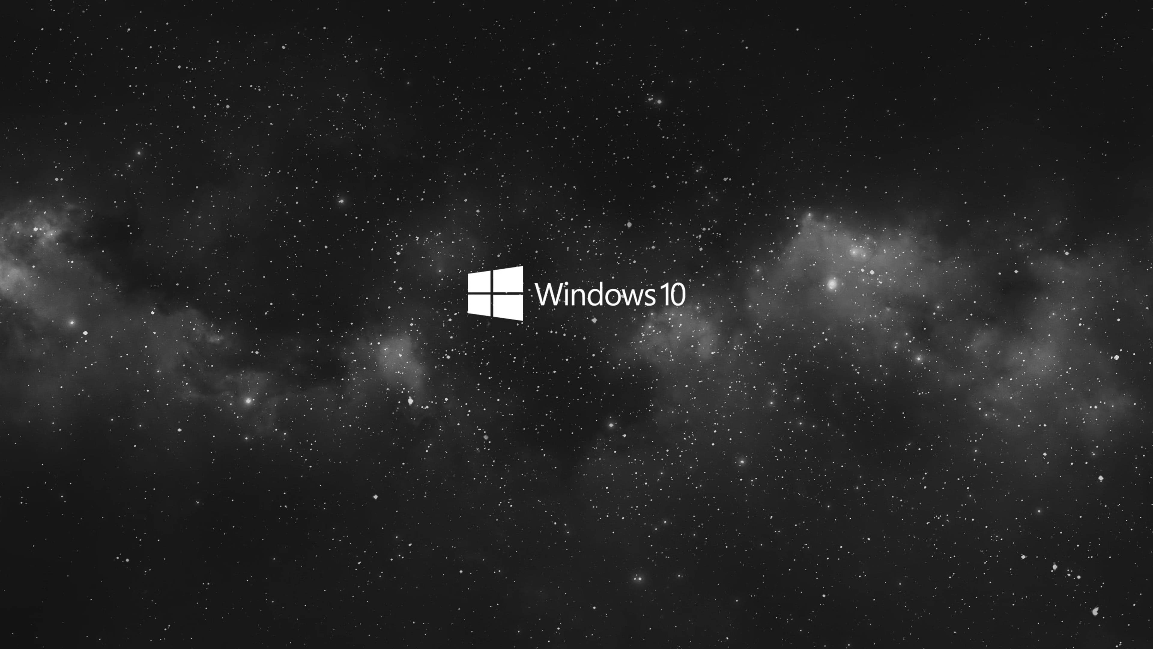 4K筆電黑色Windows 10 壁紙 — Windows 10 標誌居中置於星光點點的單色宇宙背景上，帶有星雲。