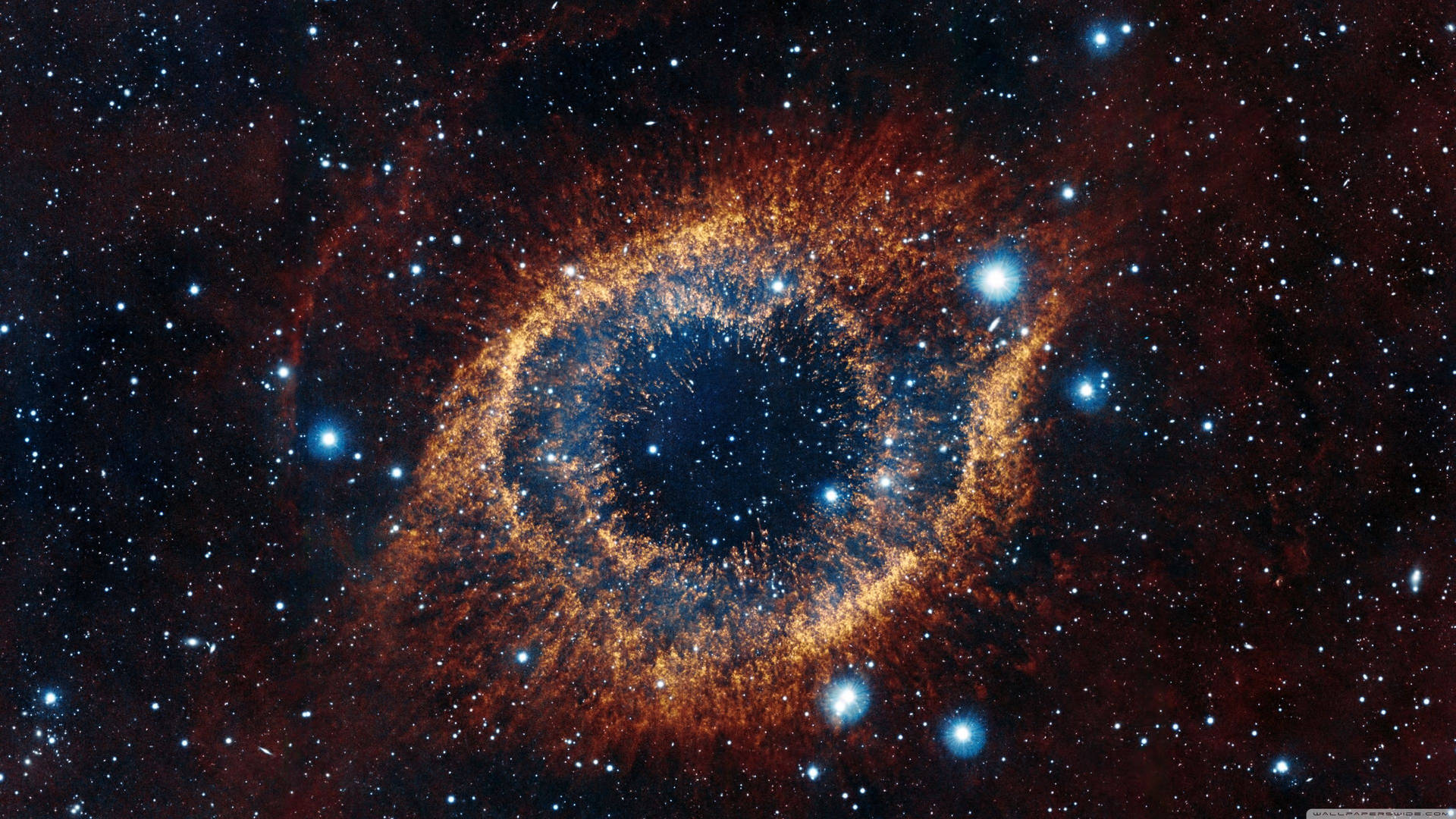 火橙色和藍色的宇宙眼狀星雲被星星包圍。 — 4K太空 壁紙