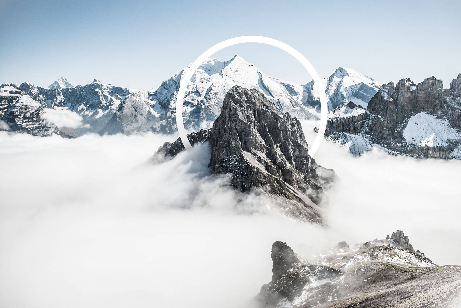 一座積雪的山峰從雲層中浮現，帶有白色圓形疊加層。
