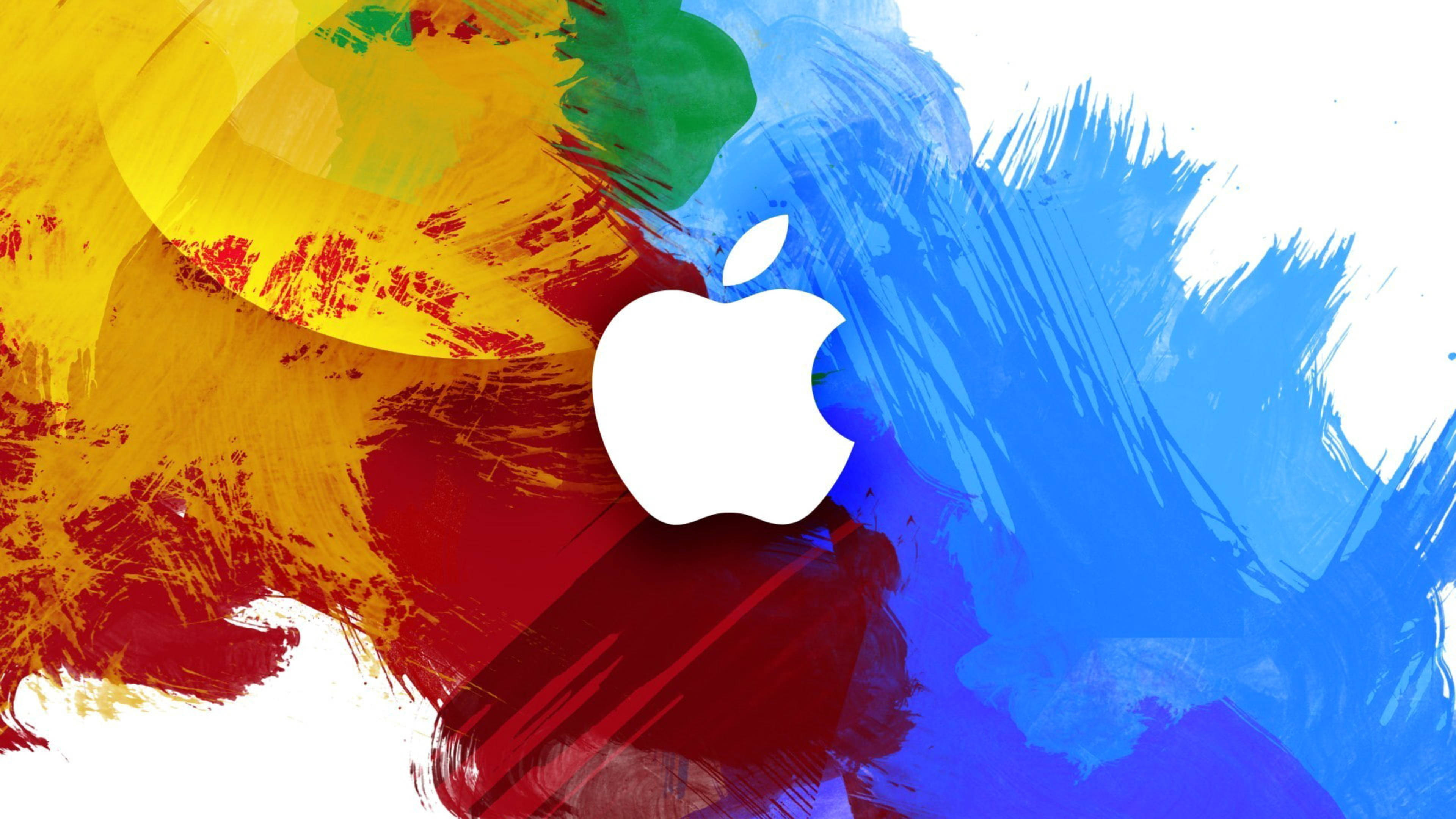 4K筆電蘋果彩色筆觸 壁紙 — 一個白色Apple標誌置於充滿活力的抽象背景中央，背景有黃、紅、藍、綠的粗獷筆觸。