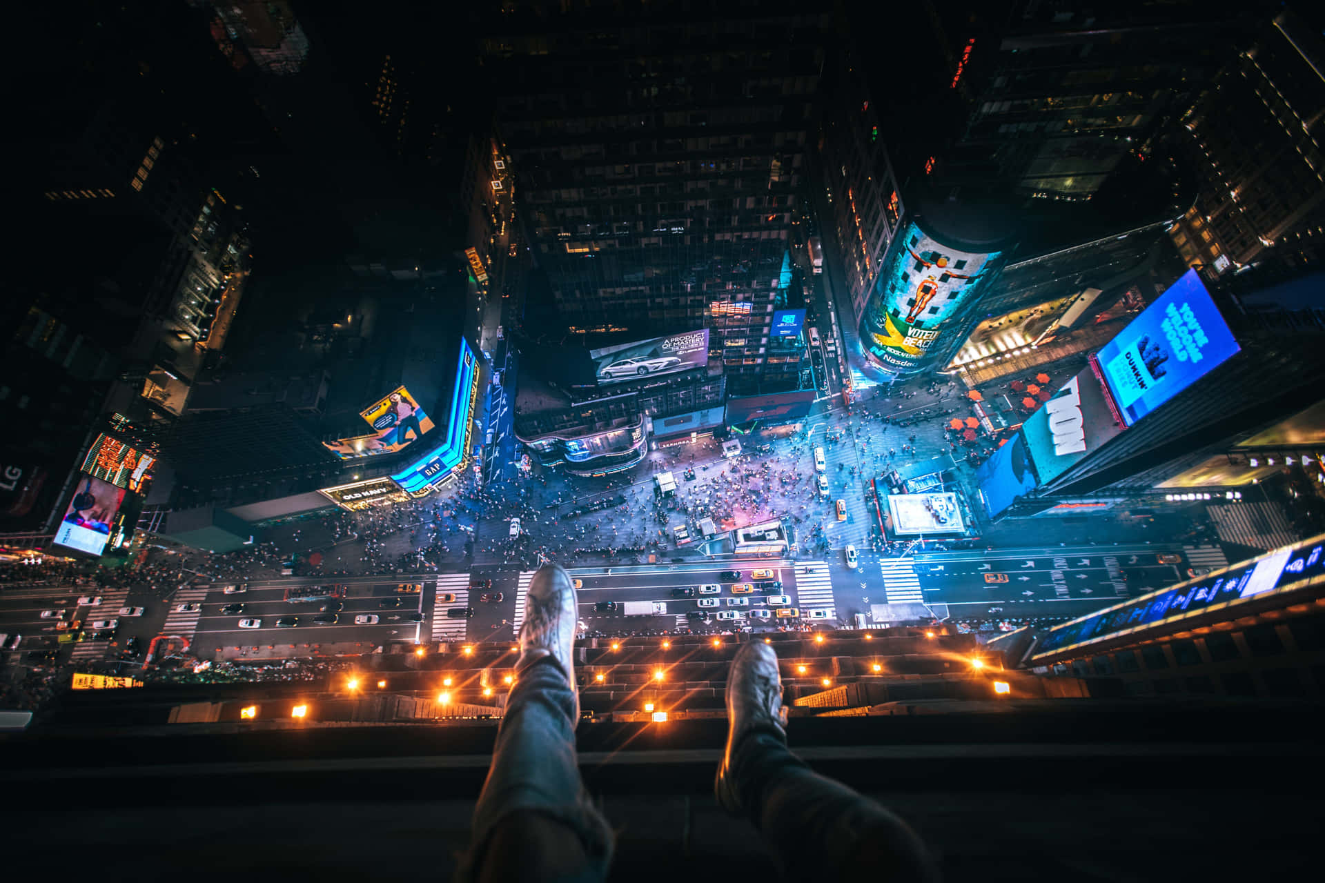 夜晚懸掛在時代廣場上空的雙腳，下方有發光的廣告牌和人群。