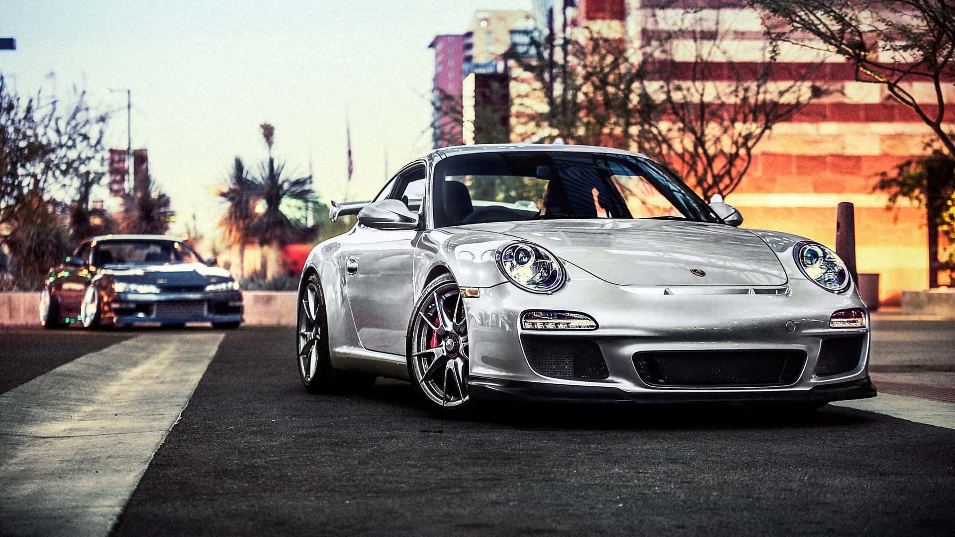 銀色保時捷911 GT3 RS停泊在日落時分的城市街道上。