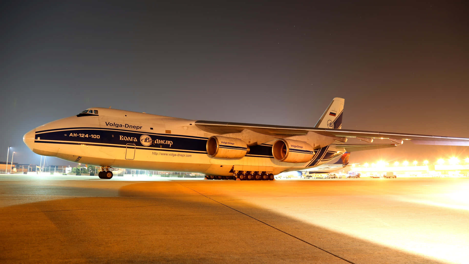 大型貨機在夜間停放在機場停機坪上，燈光明亮。