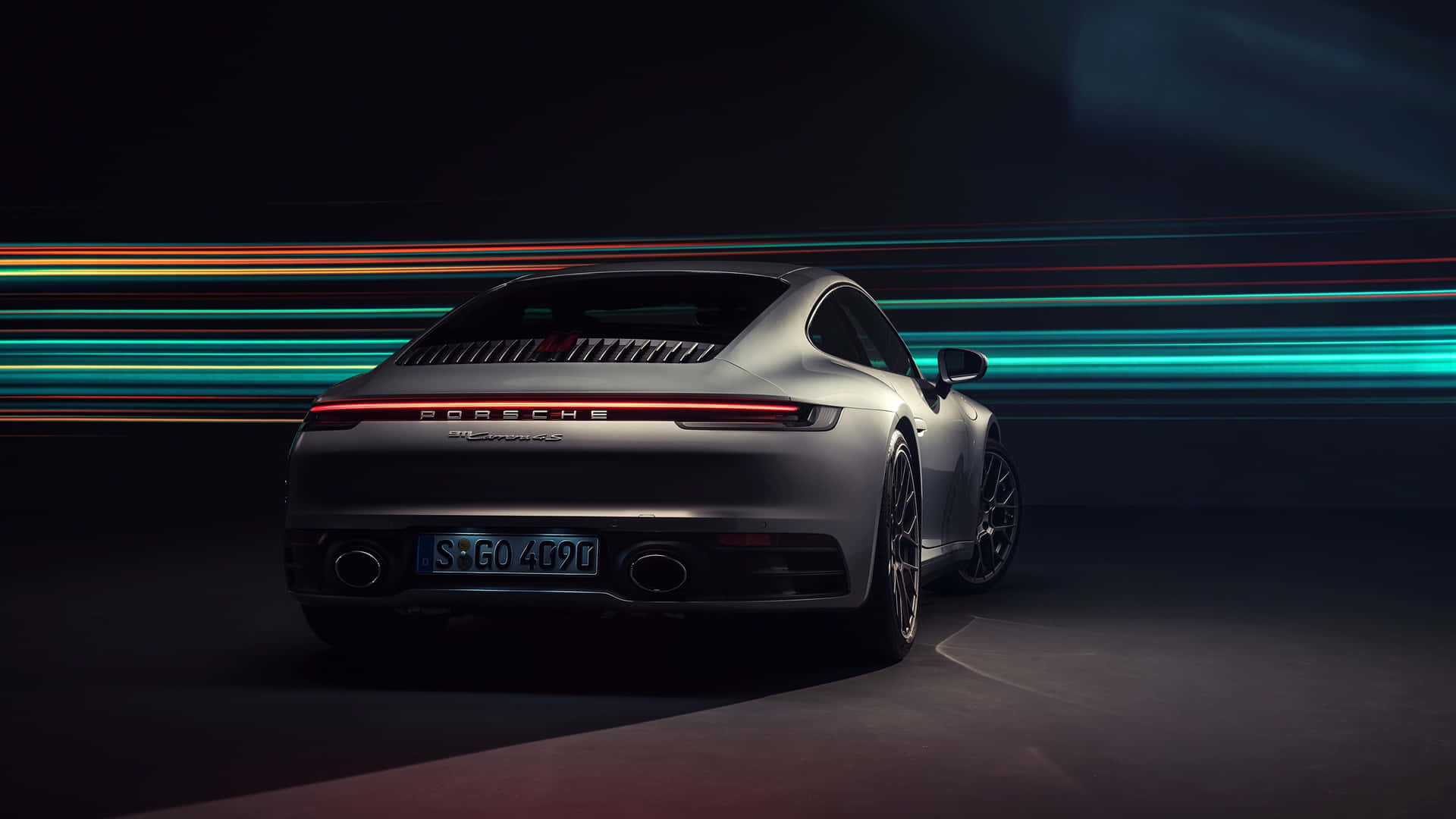 銀色保時捷911跑車，背景有霓虹燈條紋。