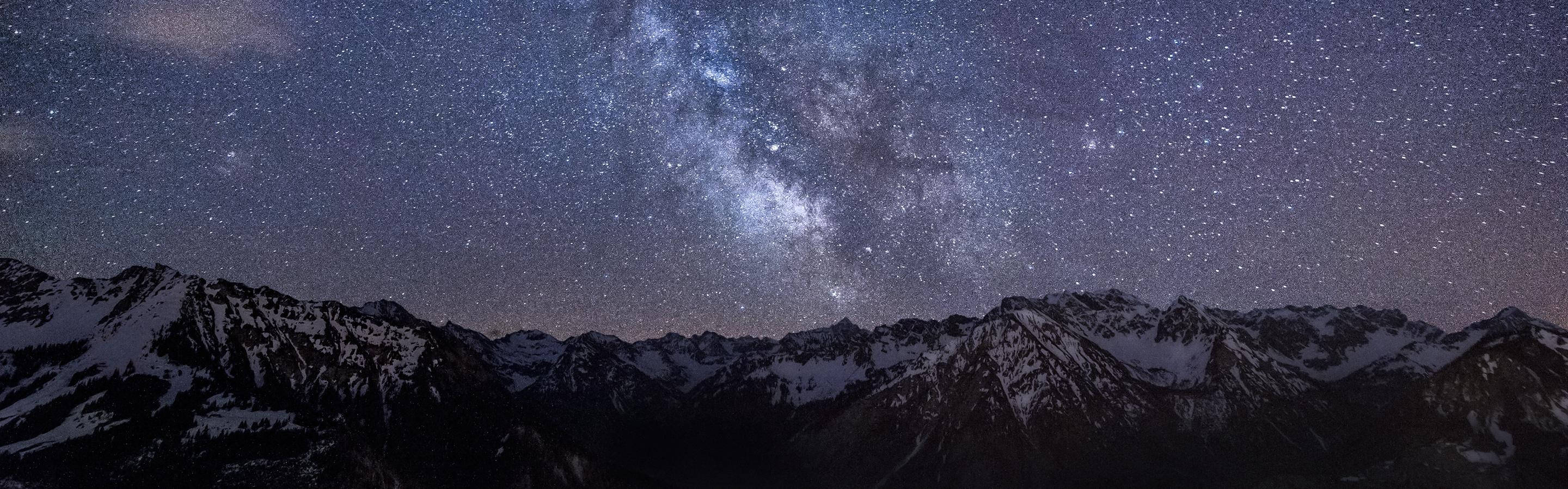 4K雙螢幕山頂繁星夜景 壁紙 — 白雪覆蓋的山峰在令人嘆為觀止的星空下聳立，銀河在夜空中閃耀。