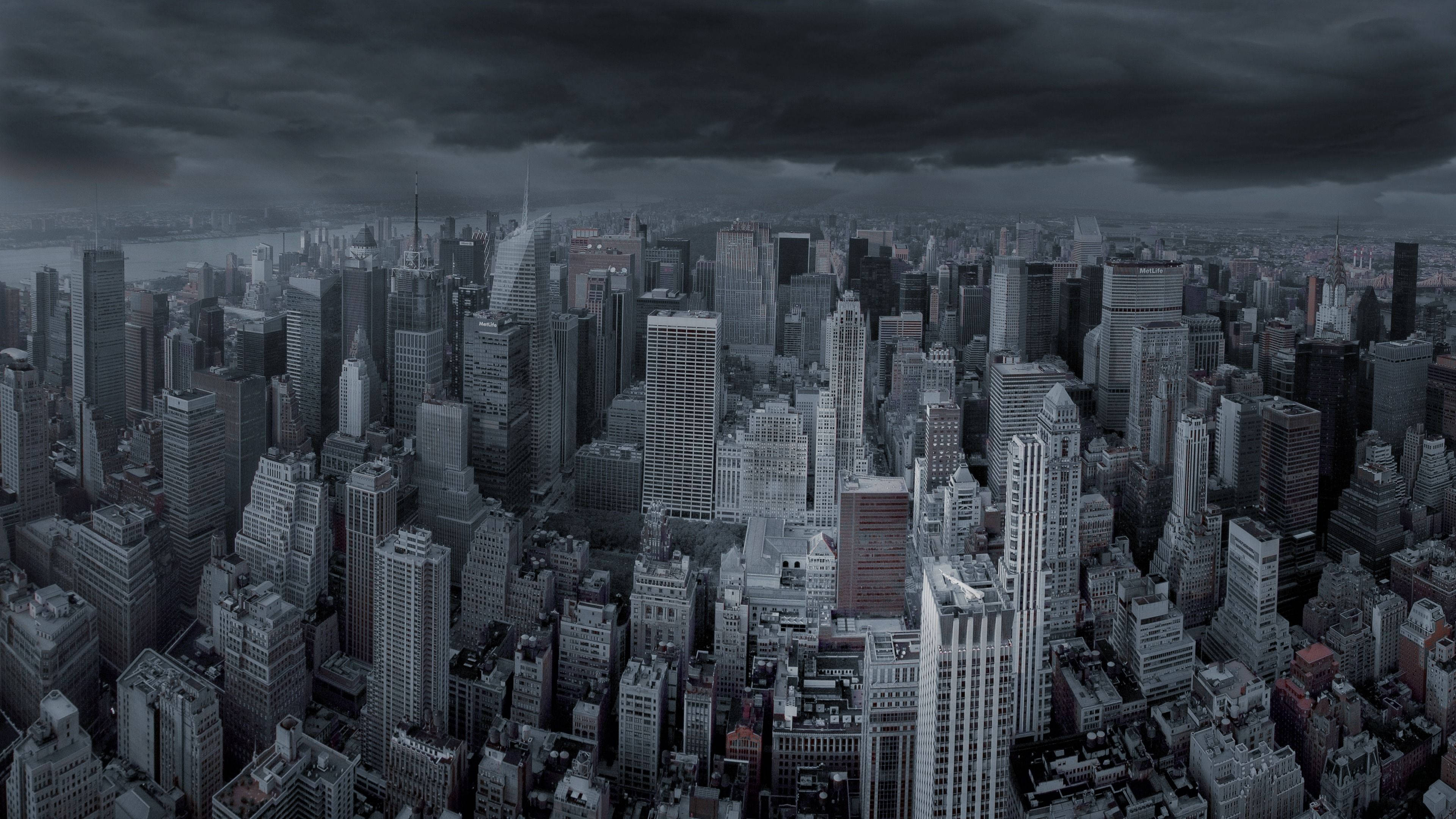 4K電腦壁紙：陰鬱城市與烏雲 壁紙 — 在厚重暴風雲層下密集城市天際線的陰鬱鳥瞰圖。
