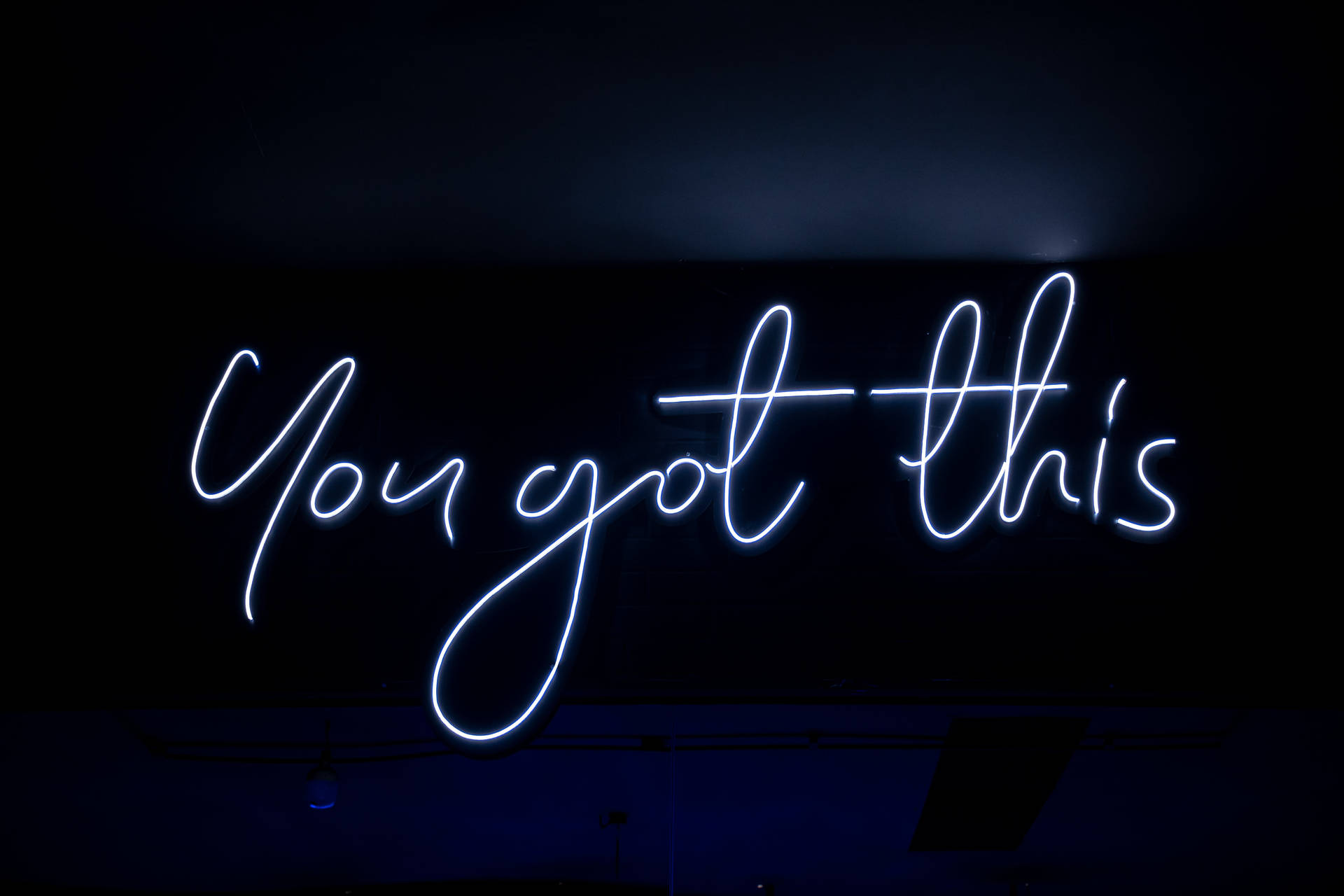 藍色霓虹燈牌在黑暗的房間中顯示 You got this。