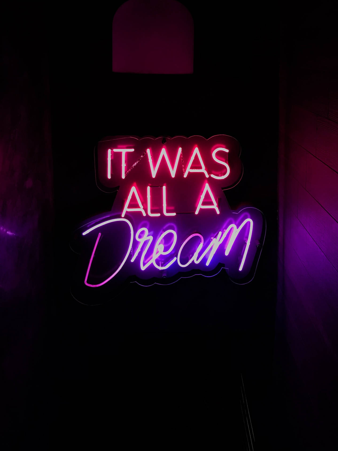 霓虹燈牌，上面寫著「It Was All A Dream」，在黑暗的房間中發出粉紅色和紫色的光芒。