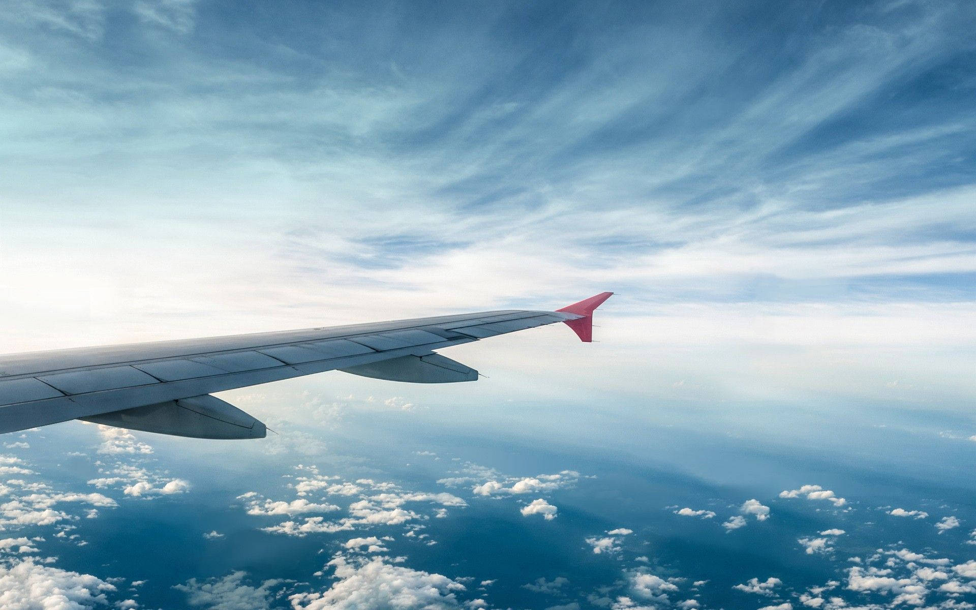 飛機機翼在晴朗藍天中翱翔於雲層之上 — 4K 飛機壁紙 壁紙