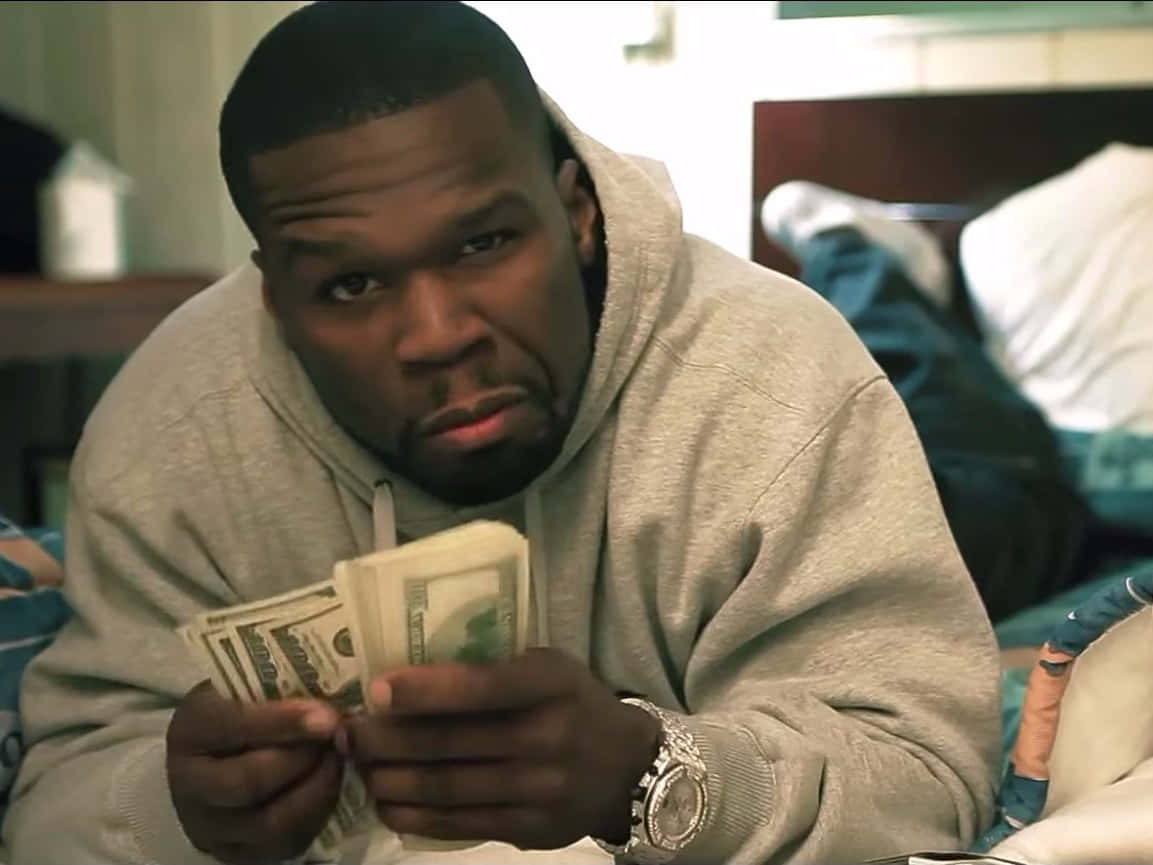 50 Cent 喺凌亂嘅睡房入面著住連帽衫數緊現金。