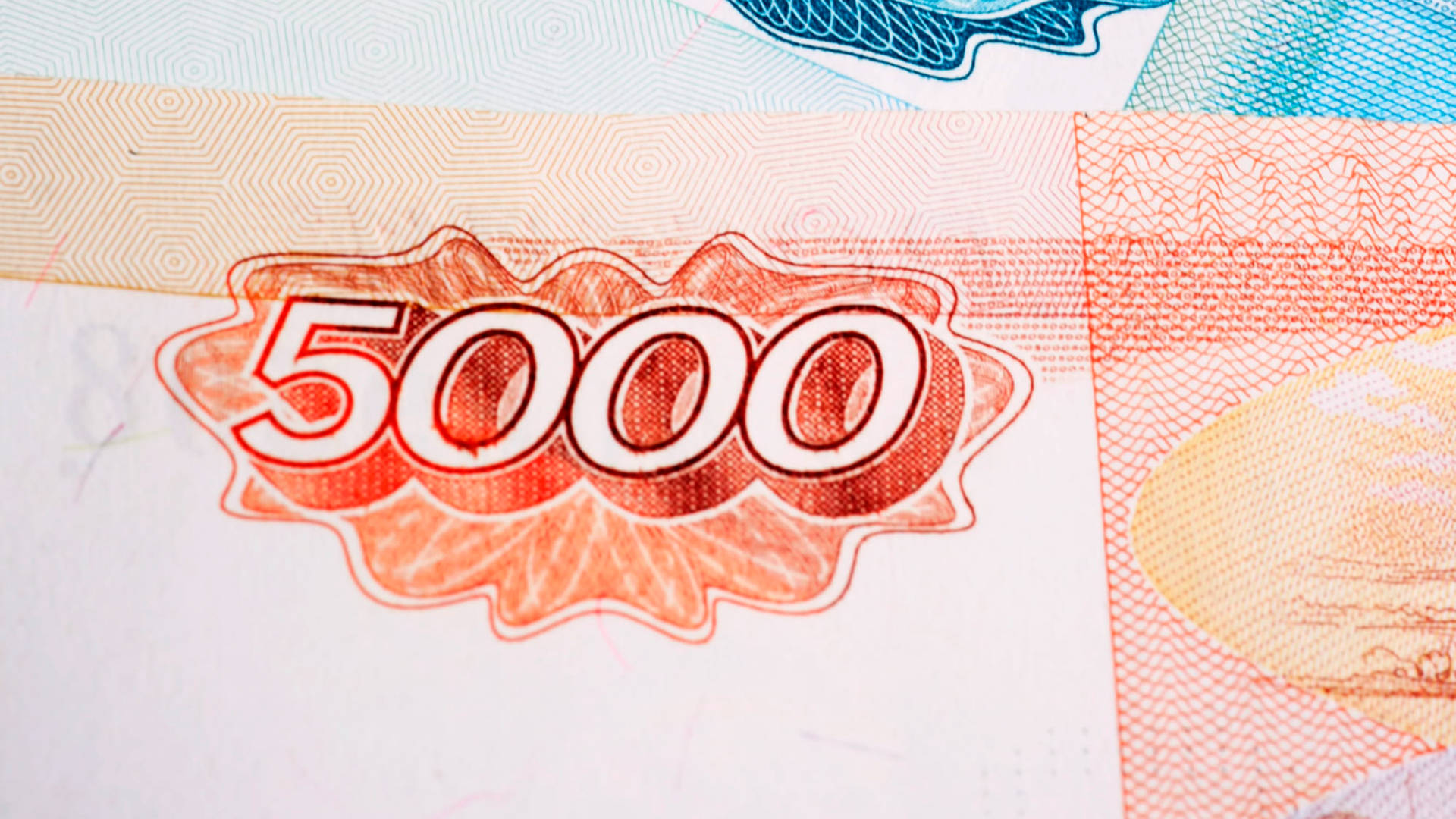 比爾斯 桌布 壁紙 — 5000元紙幣特寫，顯示複雜的橙色和藍色安全圖案及浮雕數字。