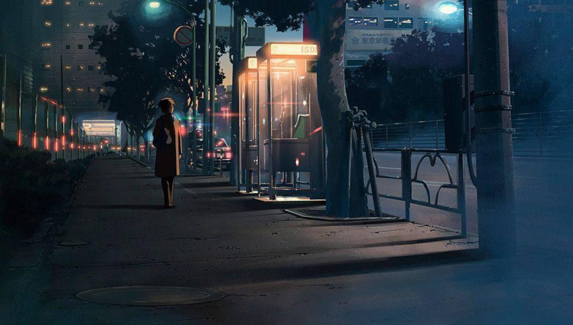 女人在夜間走過城市人行道上發光的電話亭。