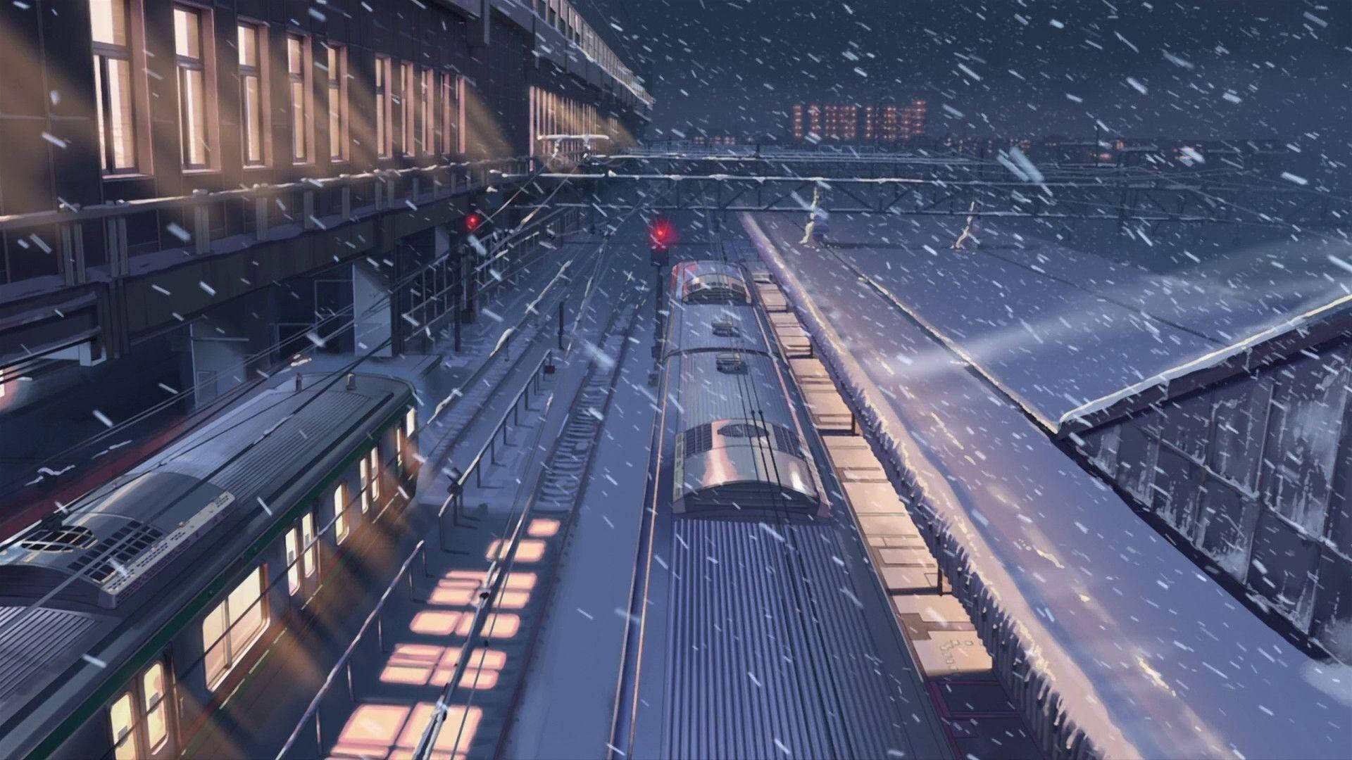 降雪覆蓋著一個燈光昏暗的火車站，有靜止的火車和發光的窗戶。