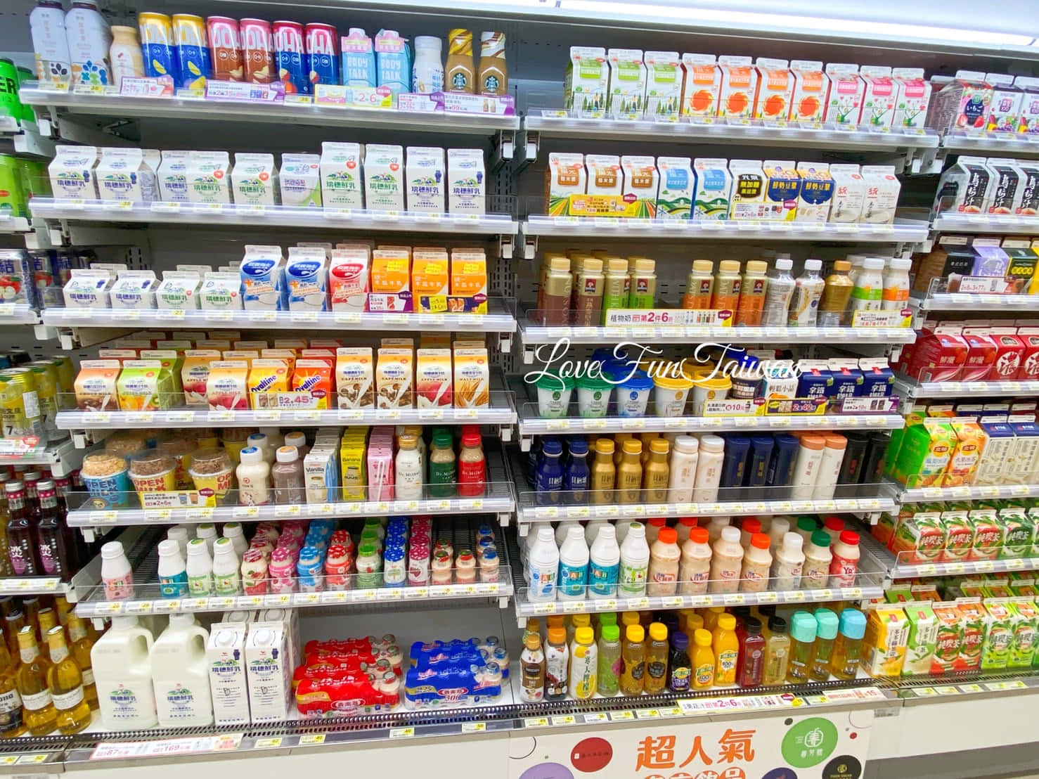 貨品齊全的超市通道，貨架上擺滿各式飲料。