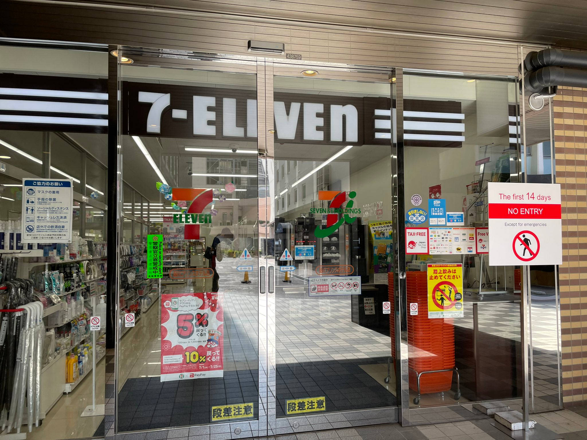 7-Eleven東京門店 壁紙 — 7-Eleven 店舖入口，玻璃門上展示宣傳標誌及首14天的「不准進入」告示。