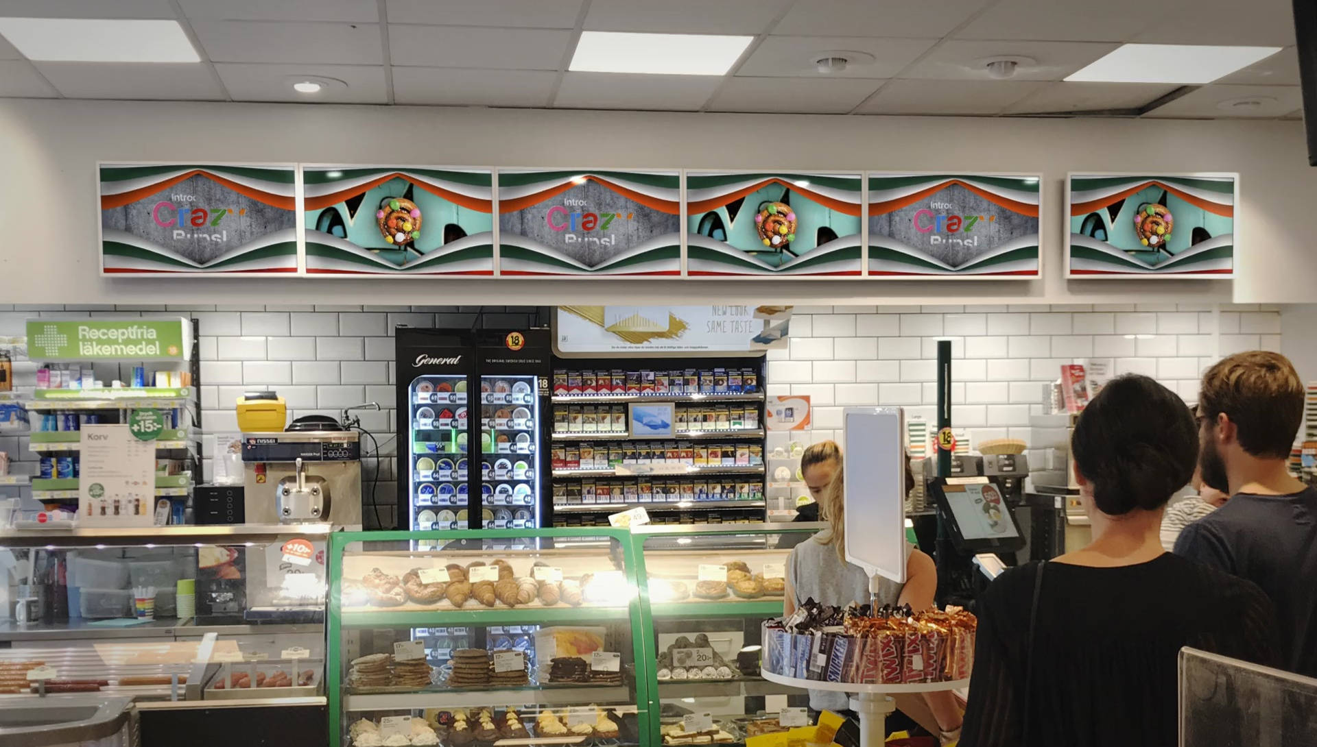 7-Eleven櫃檯 壁紙 — 顧客站在麵包店櫃檯前，下方是色彩繽紛的復古風格牆藝，帶有水果圖案和大膽的幾何波浪。