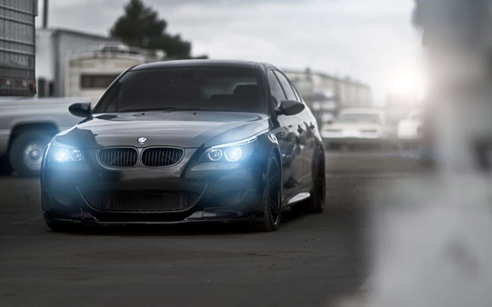 城市街道上時尚的銀色BMW M5轎車，配備明亮的車頭燈。