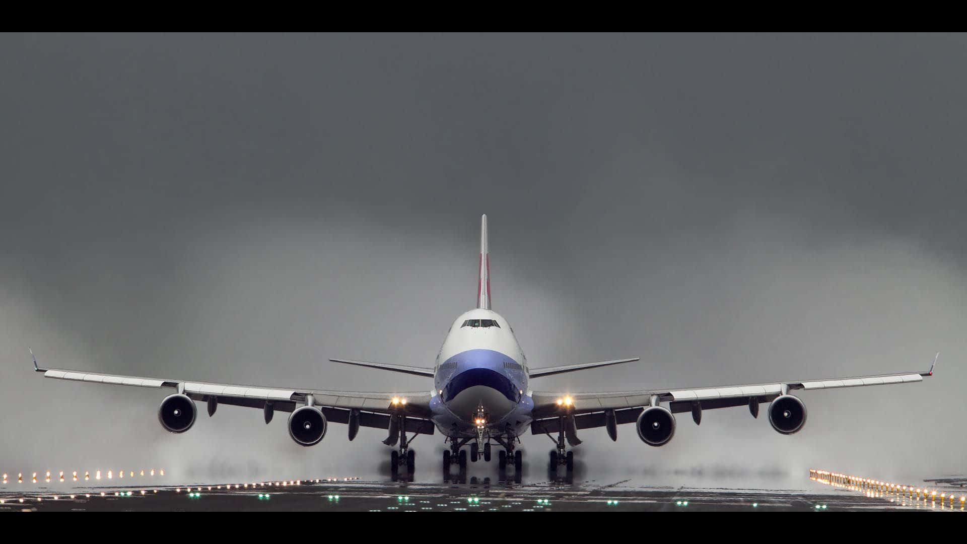 一架大型客機在暴風雨的天空下，降落在霧濛濛的跑道上。