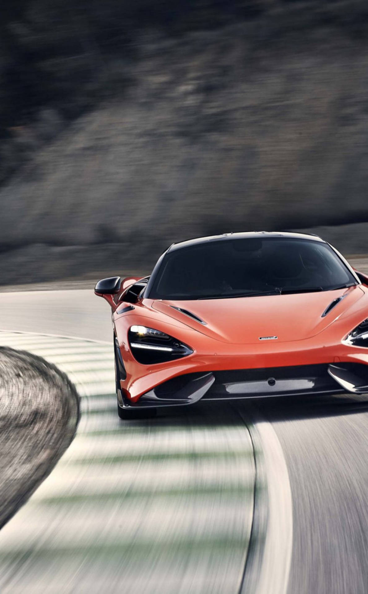 橙色McLaren跑車在蜿蜒的山路上飛馳。
