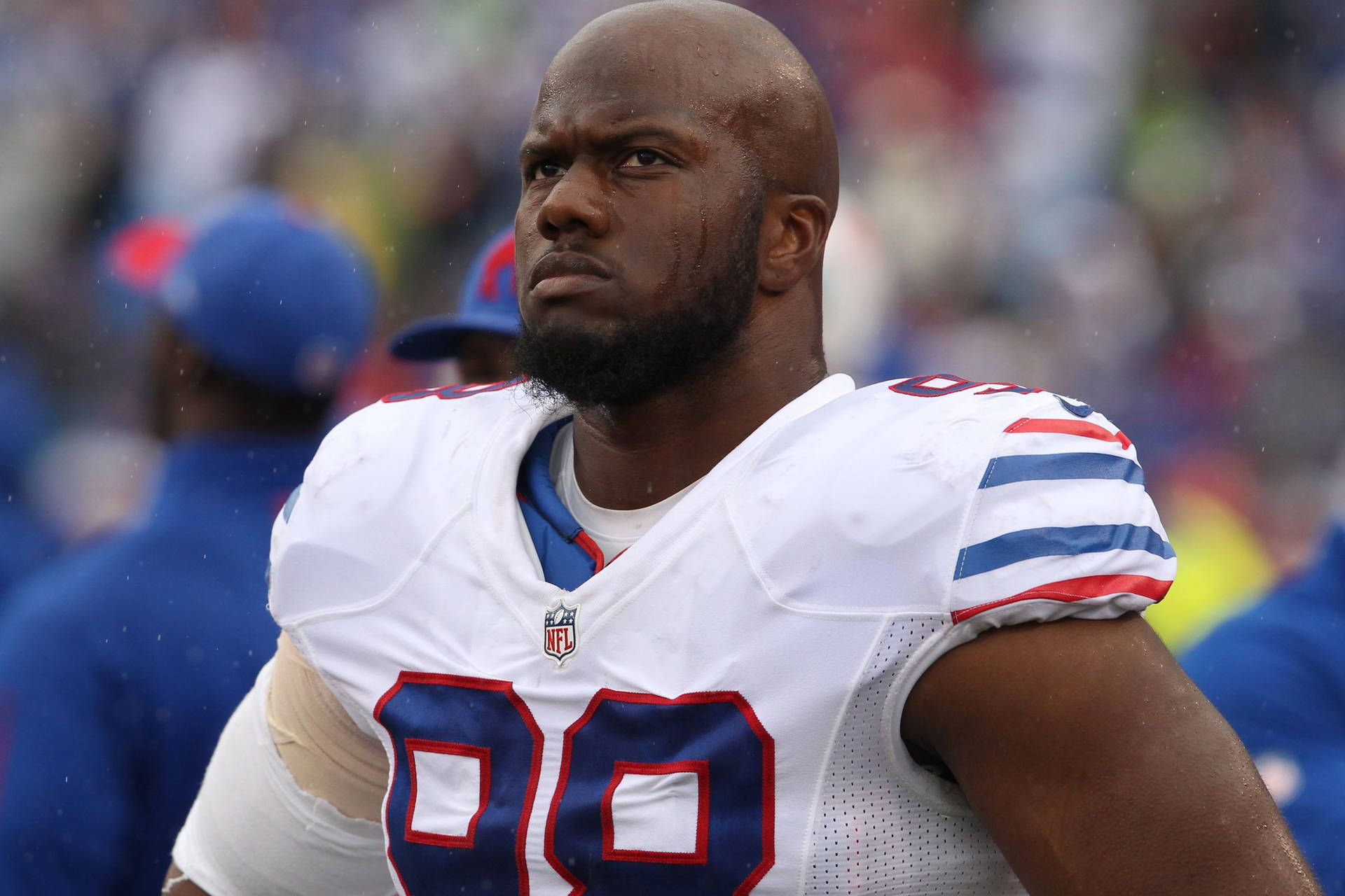 NFL足球運動員身穿99號球衣在雨中球場上。 — 水牛比爾 壁紙