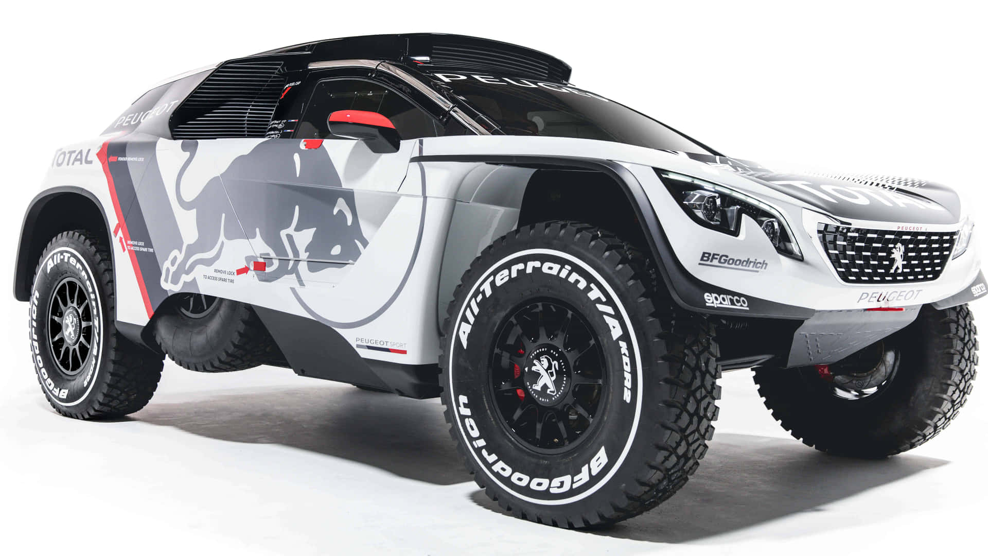 白色Peugeot拉力賽車，帶有Red Bull和BFGoodrich品牌，在白色攝影棚背景上。