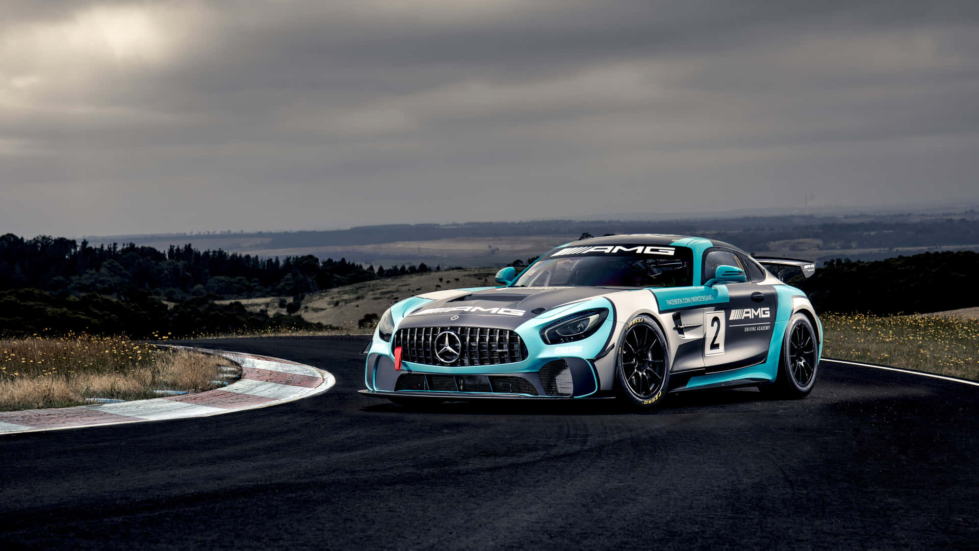 藍白色平治AMG GT3賽車在多雲的天空下行駛在蜿蜒的賽道上。
